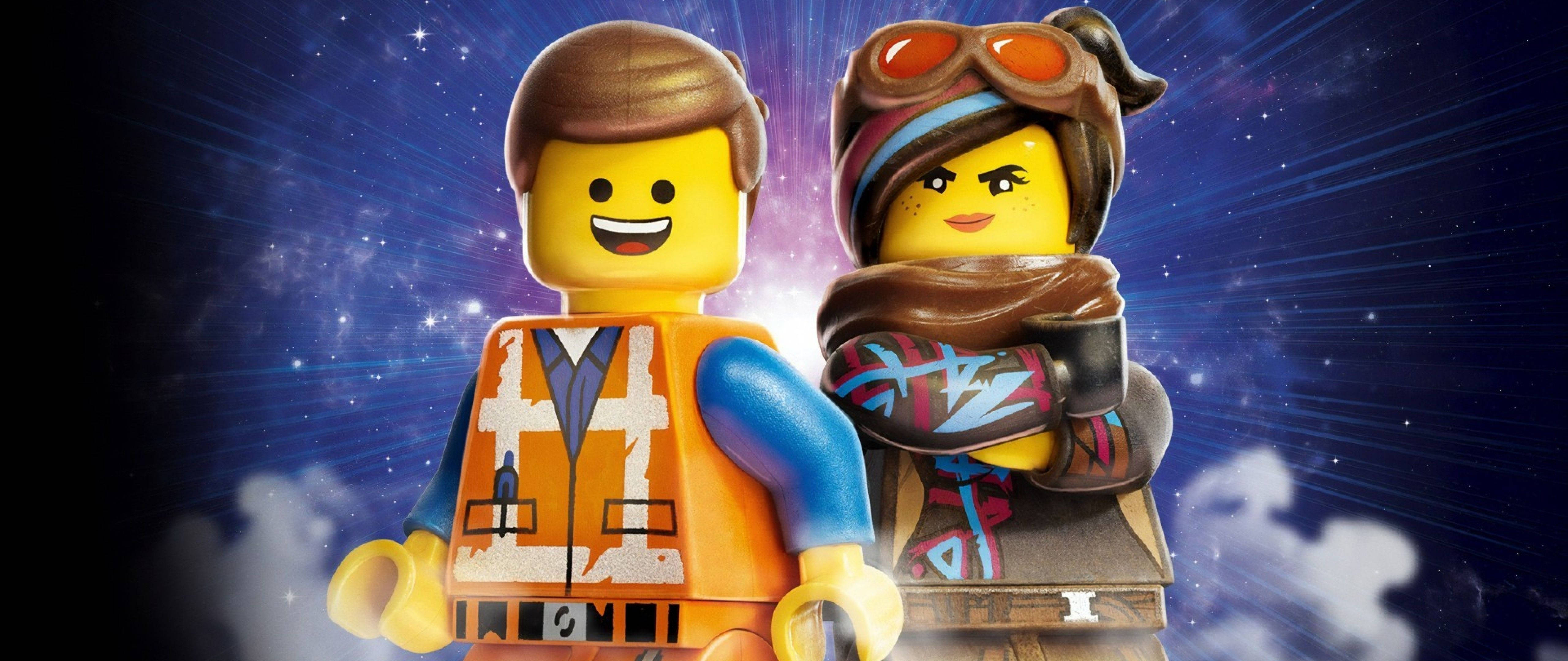 電影動圖 桌布 壁紙 — 兩個微笑的LEGO迷你人偶站在帶有雲層的宇宙星爆背景前。
