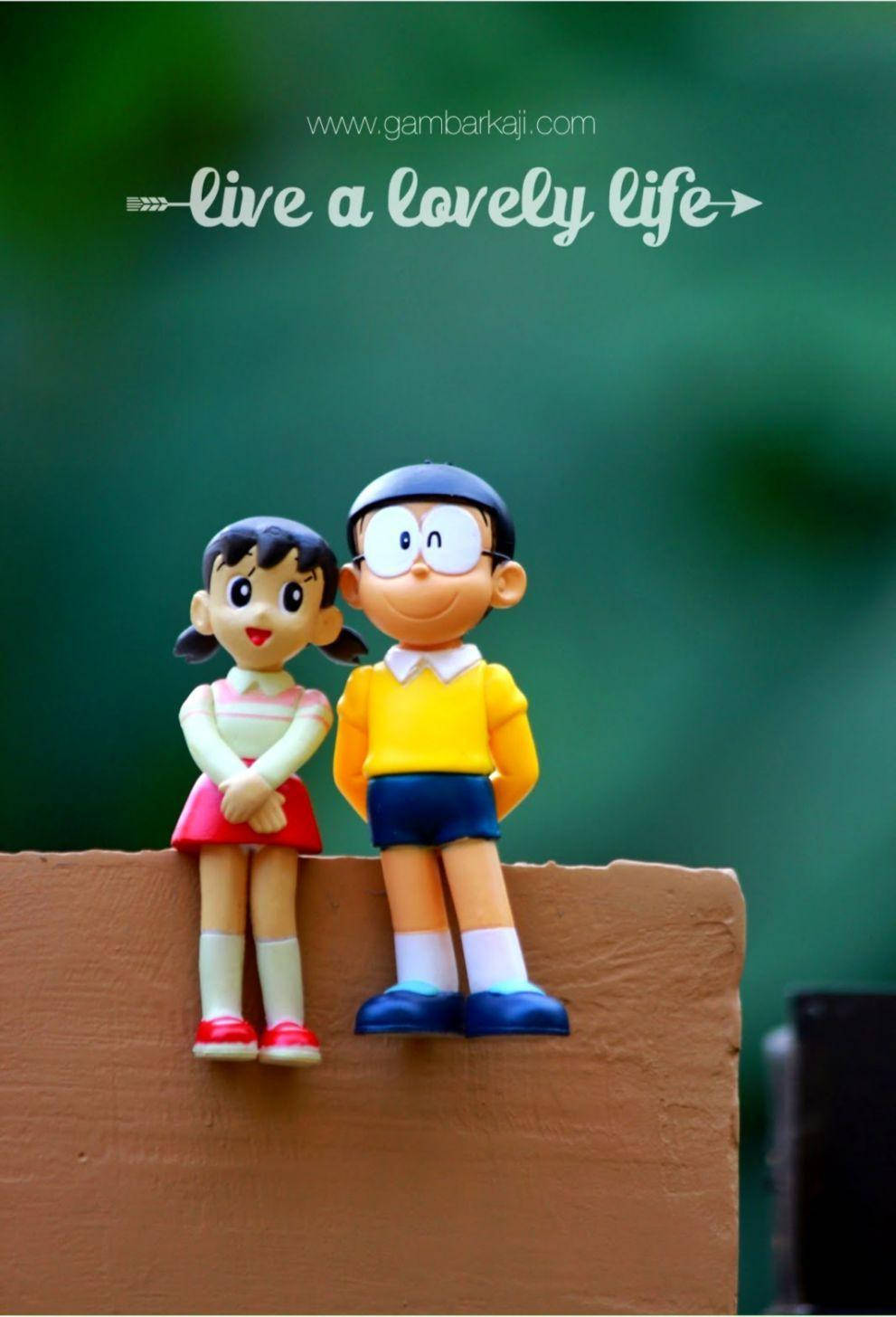 Doraemon 桌布 壁紙 — 兩個微笑的動漫人物並排坐在木架上，背景是柔和的綠色。
