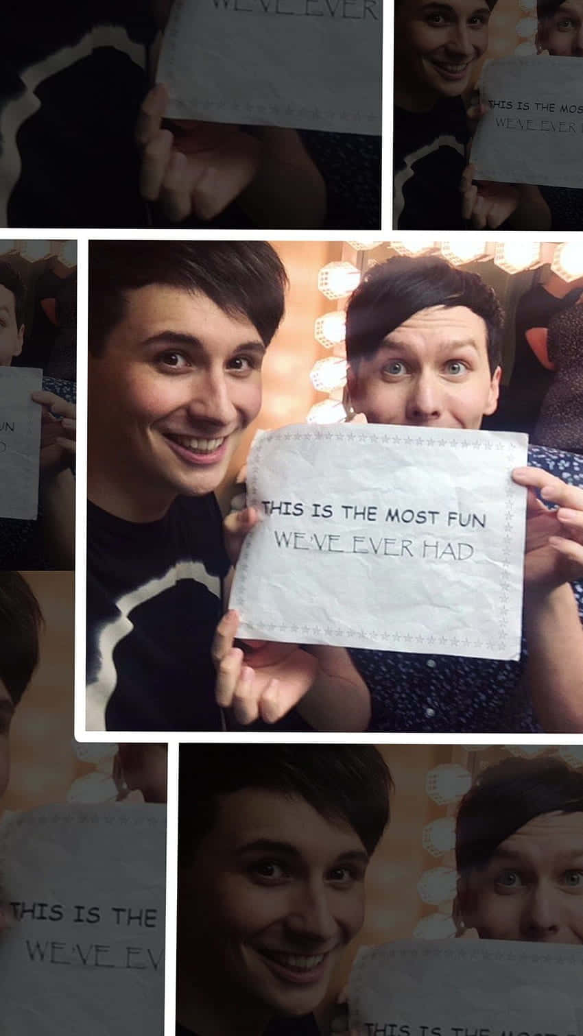 dan and phil 桌布 壁紙 — 兩個微笑的男人舉起牌子，上面寫著「這是我們有過最快樂的時光」，房間裡有溫暖的燈光和化妝燈。