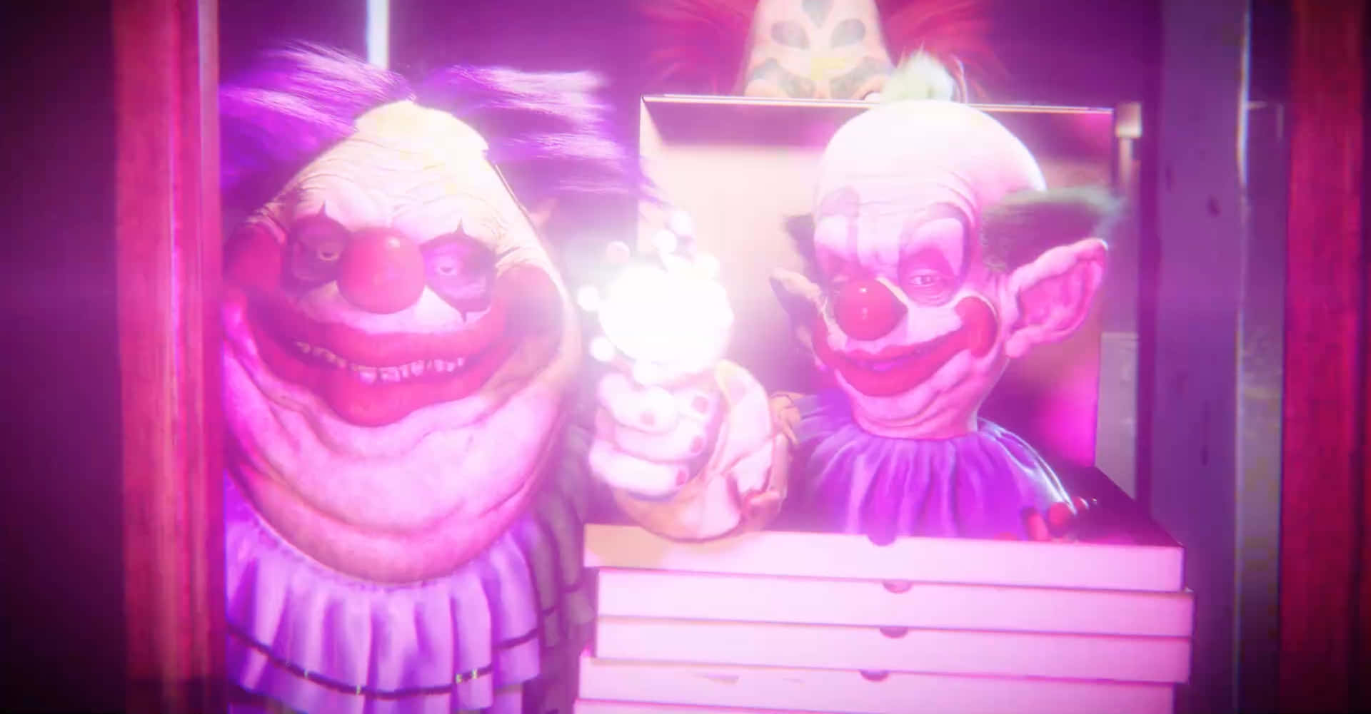killer klowns from outer space 桌布 壁紙 — 兩個怪誕的小丑，咧嘴大笑，紅鼻子在紫光下發光，其中一個在堆疊的盒子旁邊拿著一個發光的物體。