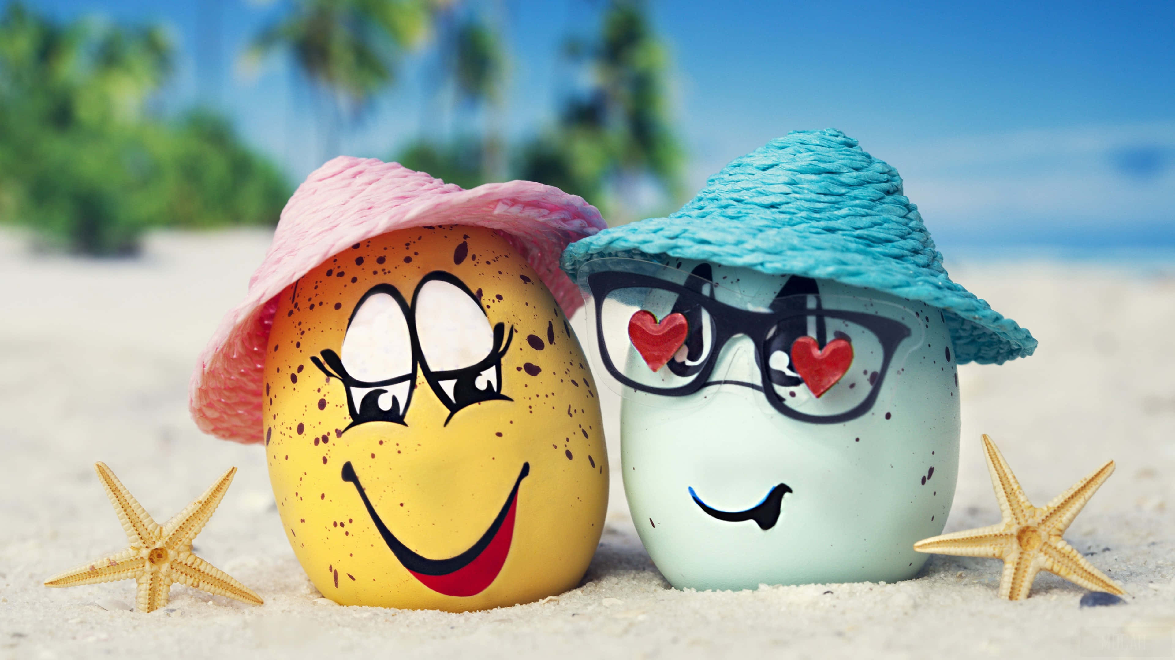 Summer Beach 桌布 壁紙 — 兩個戴帽子和眼鏡的笑臉卡通雞蛋坐在沙灘上，背景有海星和棕櫚樹。
