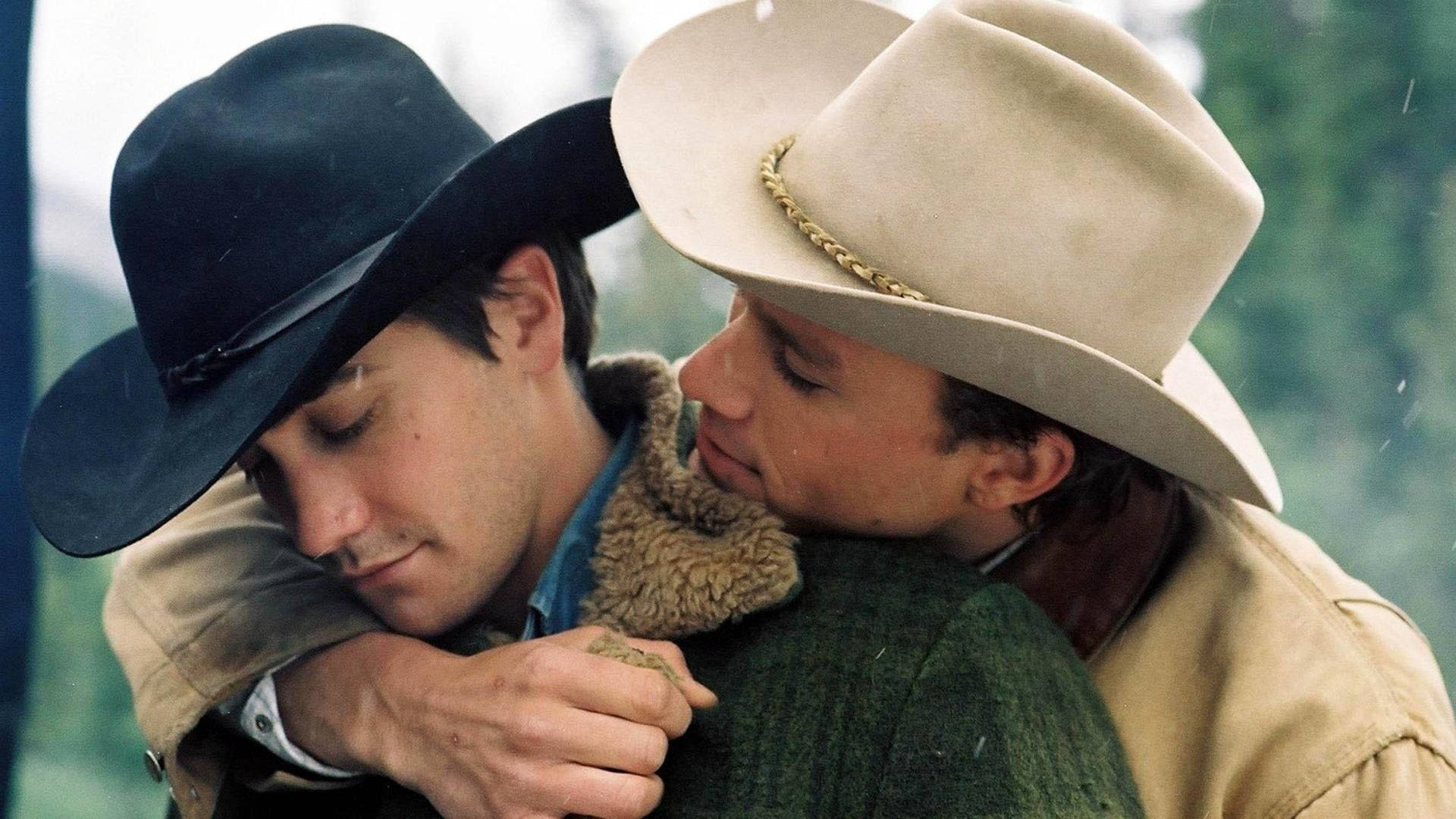 brokeback mountain 桌布 壁紙 — 兩個戴牛仔帽的男人在薄霧森林中，柔和自然光下溫柔擁抱。