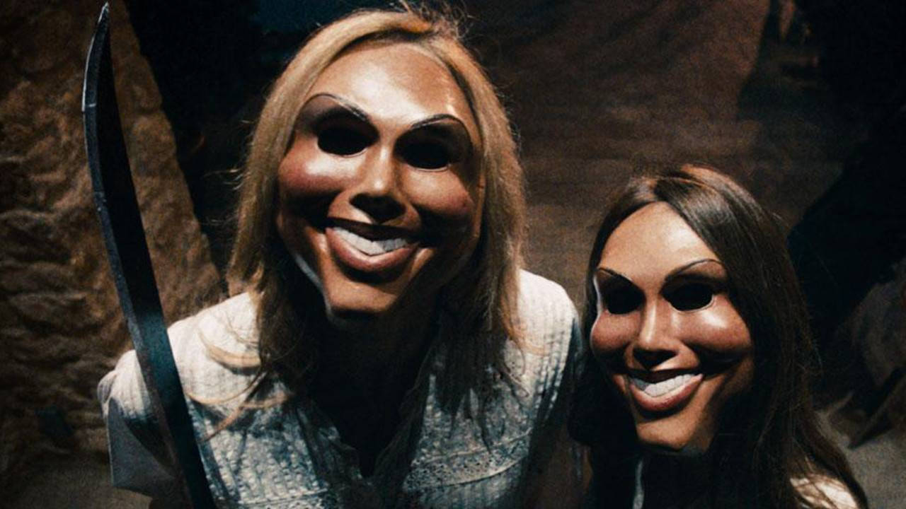 Purge 桌布 壁紙 — 兩個戴著令人不安的歡樂面具的人物，在黑暗紋理背景前握著一把彎曲的刀片。