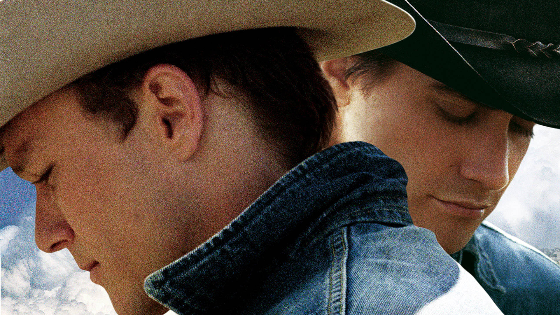 brokeback mountain 桌布 壁紙 — 兩個戴著牛仔帽和牛仔夾克的男人在陰天向下凝視，氣氛溫柔。