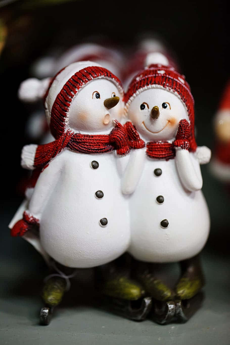 兩個戴著紅色帽子和圍巾的雪人公仔穿著溜冰鞋。 — 雪人 壁紙