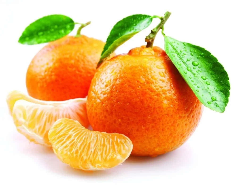 Winter Fruits 桌布 壁紙 — 兩個新鮮的柑橘，帶有露水的綠葉和剝好的瓣，在純白背景下閃閃發光。