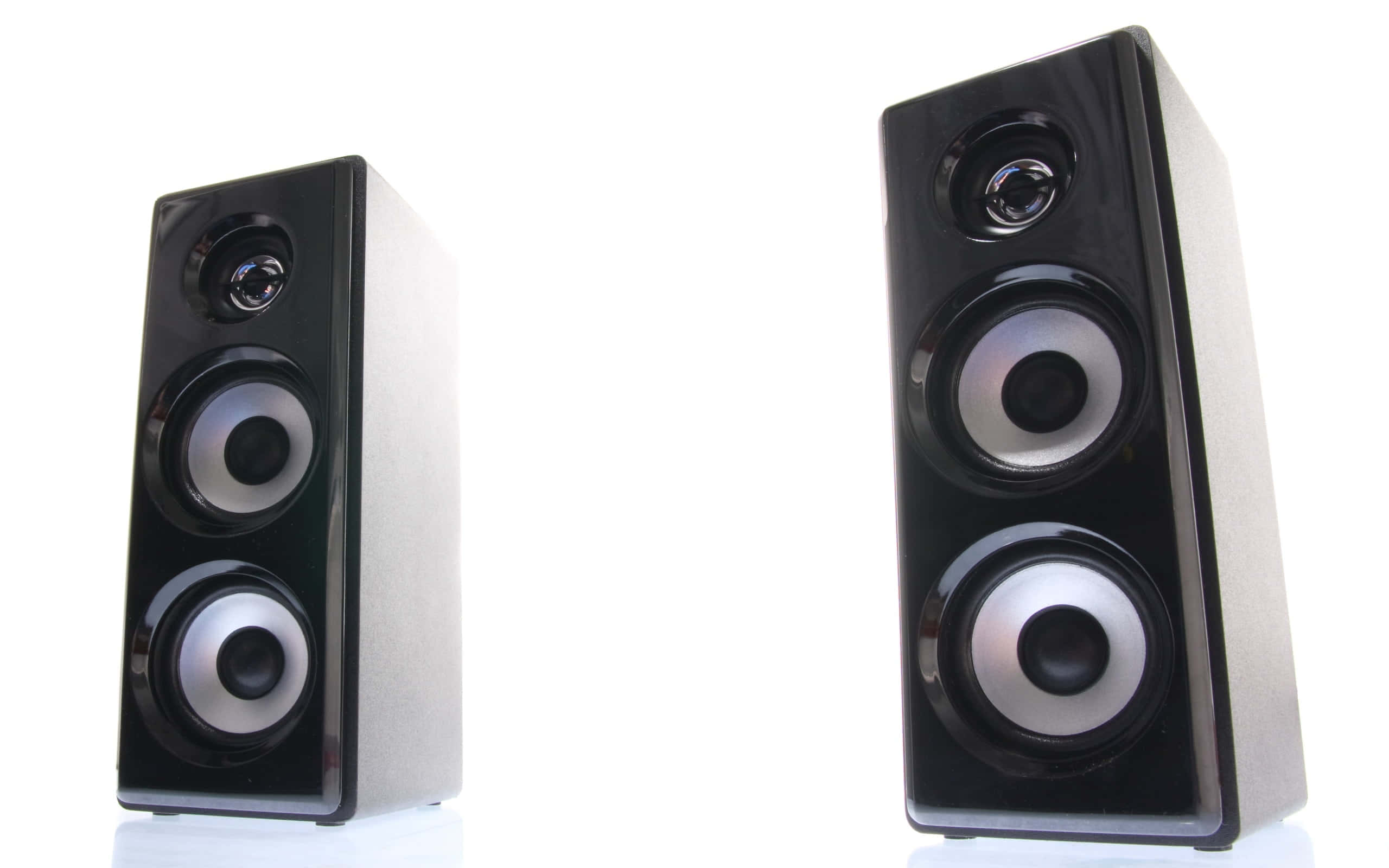 Speaker 桌布 壁紙 — 兩個時尚的黑色塔式揚聲器帶有銀色錐體，對稱地立在純白色背景前。