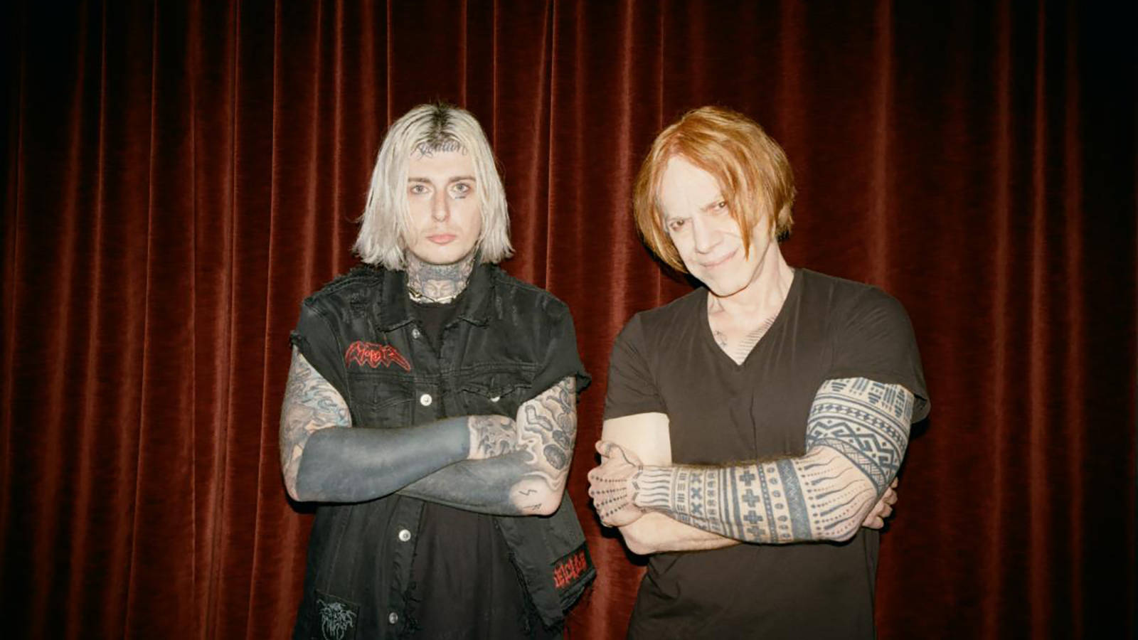 Ghostemane 桌布 壁紙 — 兩個有刺青、化著蒼白妝容、交叉雙臂的人站在深紅色天鵝絨窗簾前。