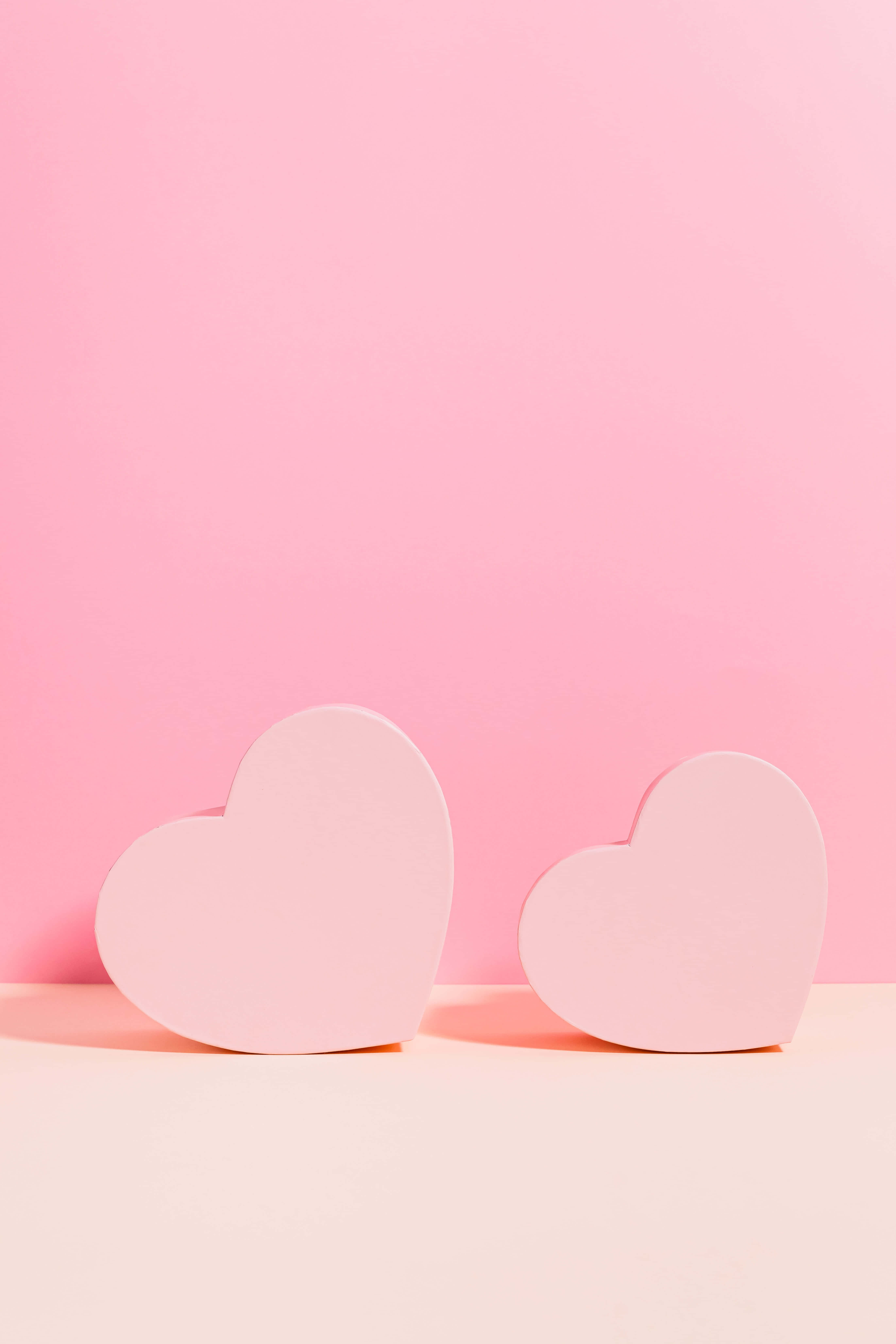 Aesthetic Heart 桌布 壁紙 — 兩個柔軟的粉紅色心形放在淡色表面上，背景是漸變粉紅色。