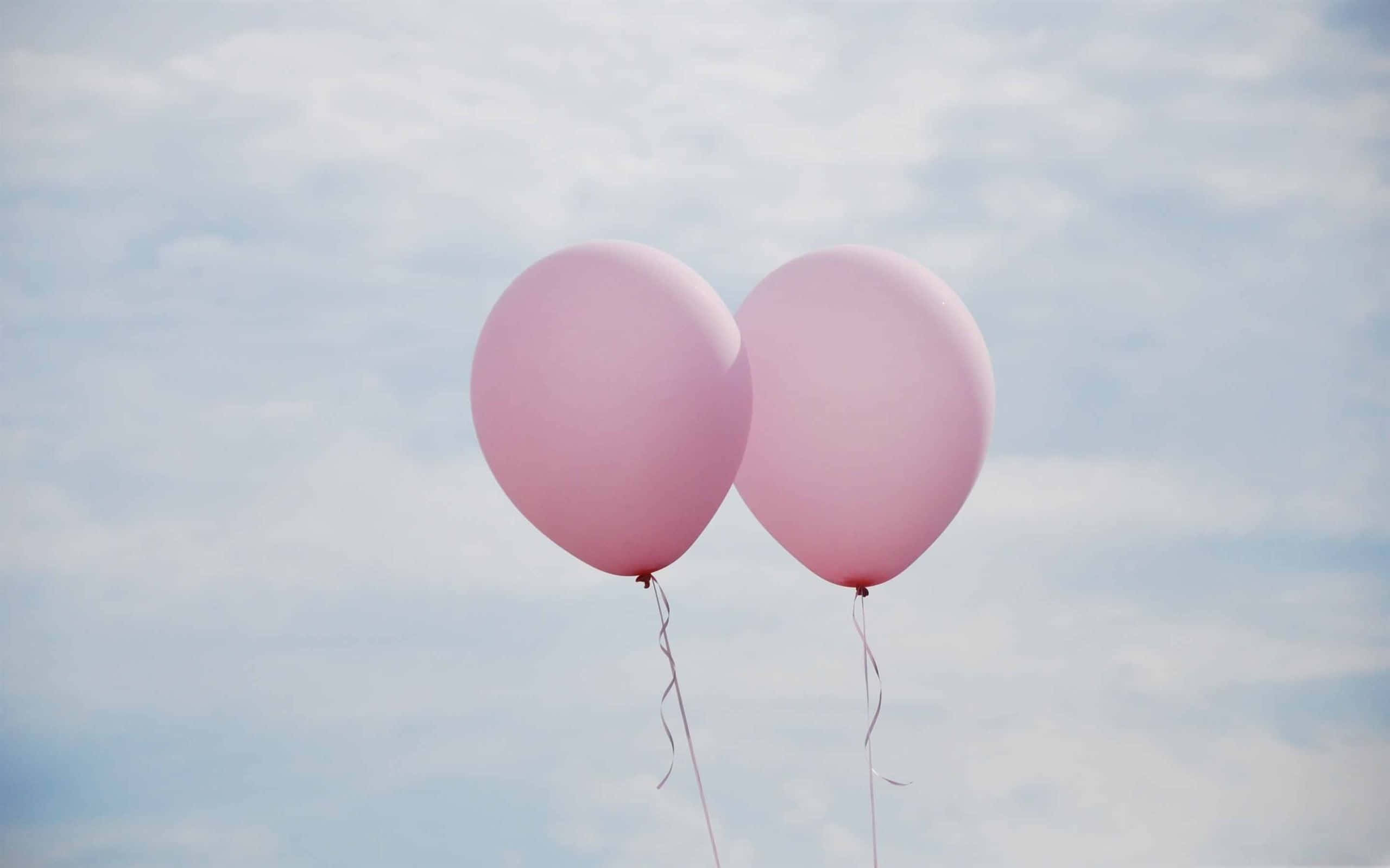 Pink Balloons 桌布 壁紙 — 兩個柔軟的粉紅色氣球在淡藍色的天空和縷縷白雲中輕輕飄浮。