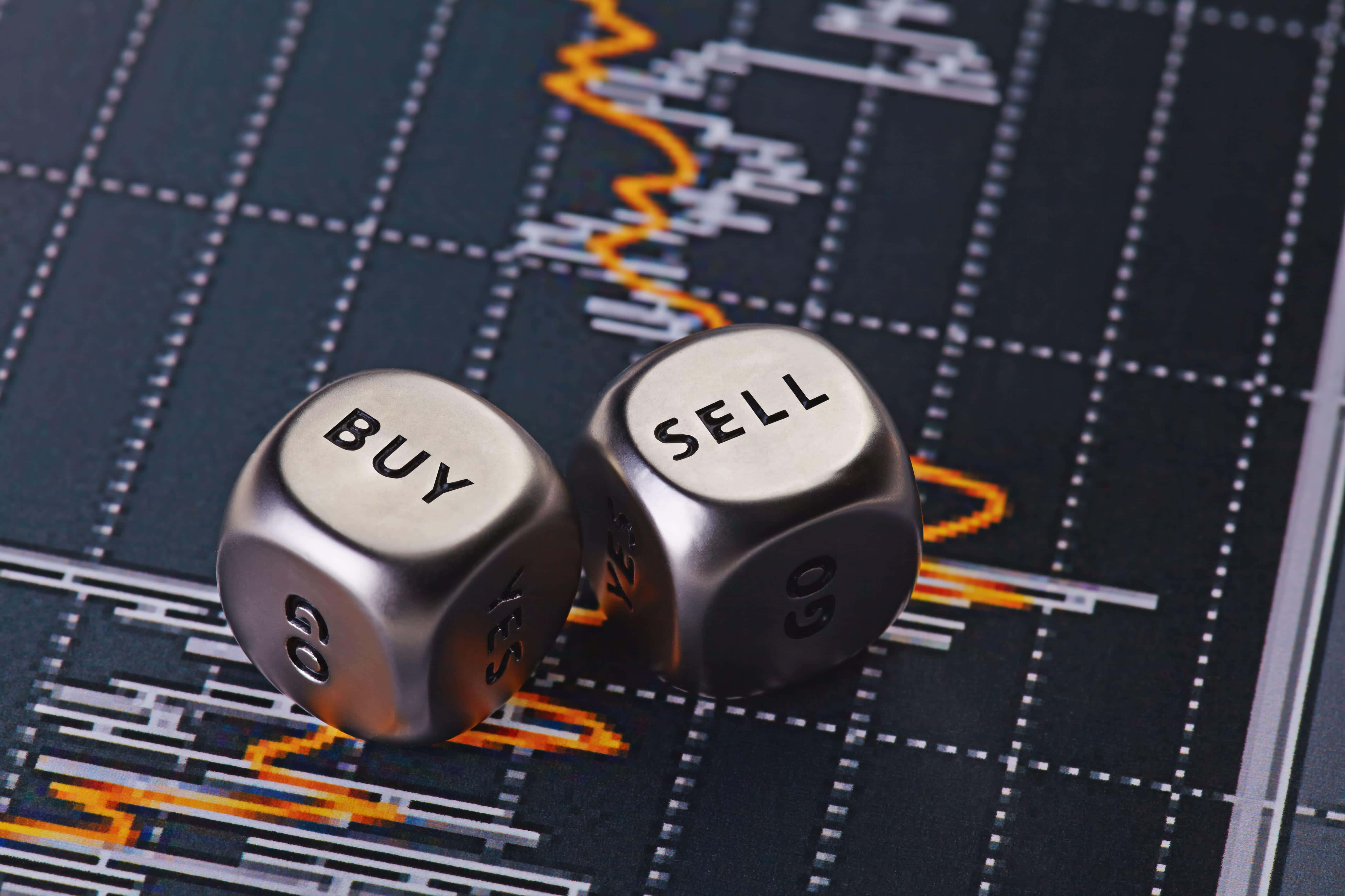Forex 桌布 壁紙 — 兩個標有「買入」和「賣出」的金屬骰子放在帶有橙色和白色線條的金融圖表上。
