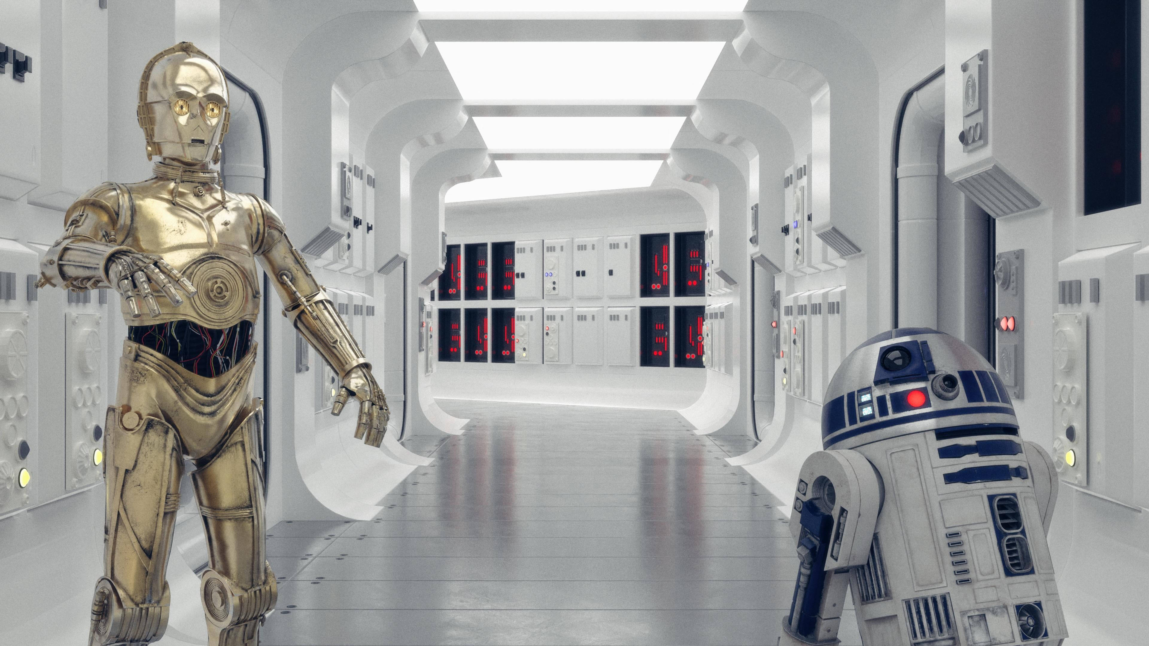 放大 桌布 壁紙 — 兩個標誌性機器人 C-3PO 和 R2-D2 站在一條未來風格的白色太空船走廊中，帶有發光的紅色面板。