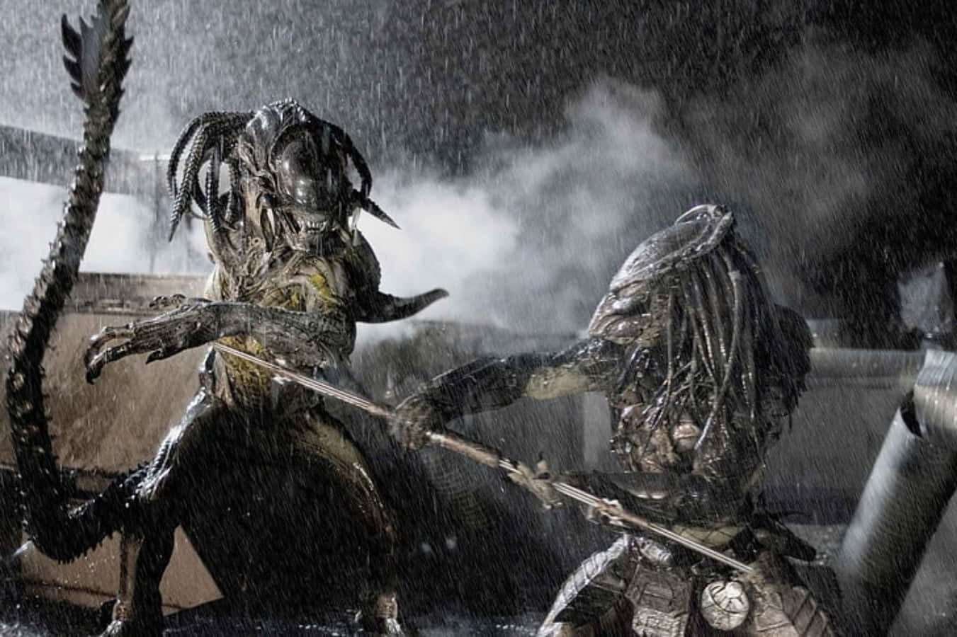 Alien Vs Predator 桌布 壁紙 — 兩個生物機械外星人在被雨水浸透的工業廢墟中碰撞，蒸汽和碎片飛揚。