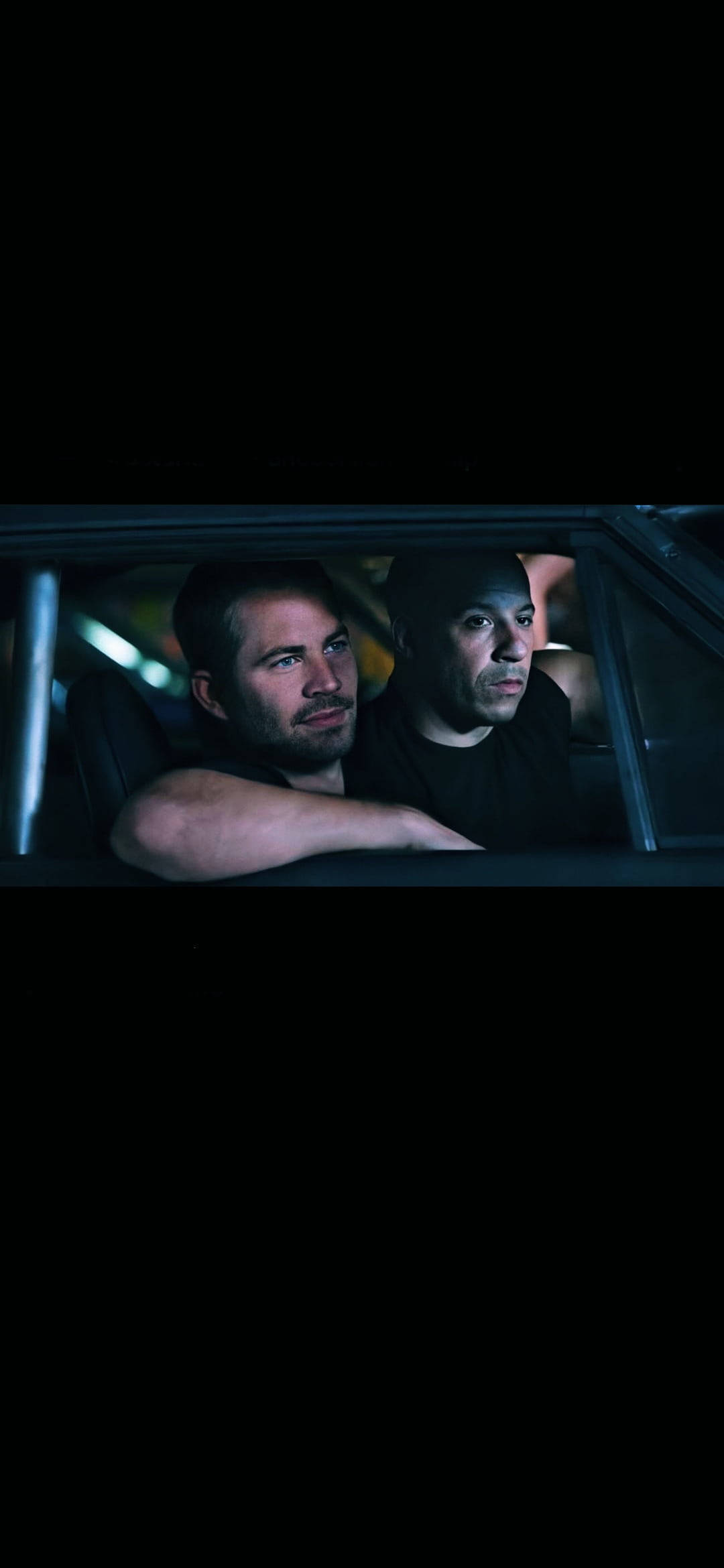 Paul Walker 桌布 壁紙 — 兩個男人在夜間的車內，在昏暗的路燈下，神情嚴肅地專注向前凝視。