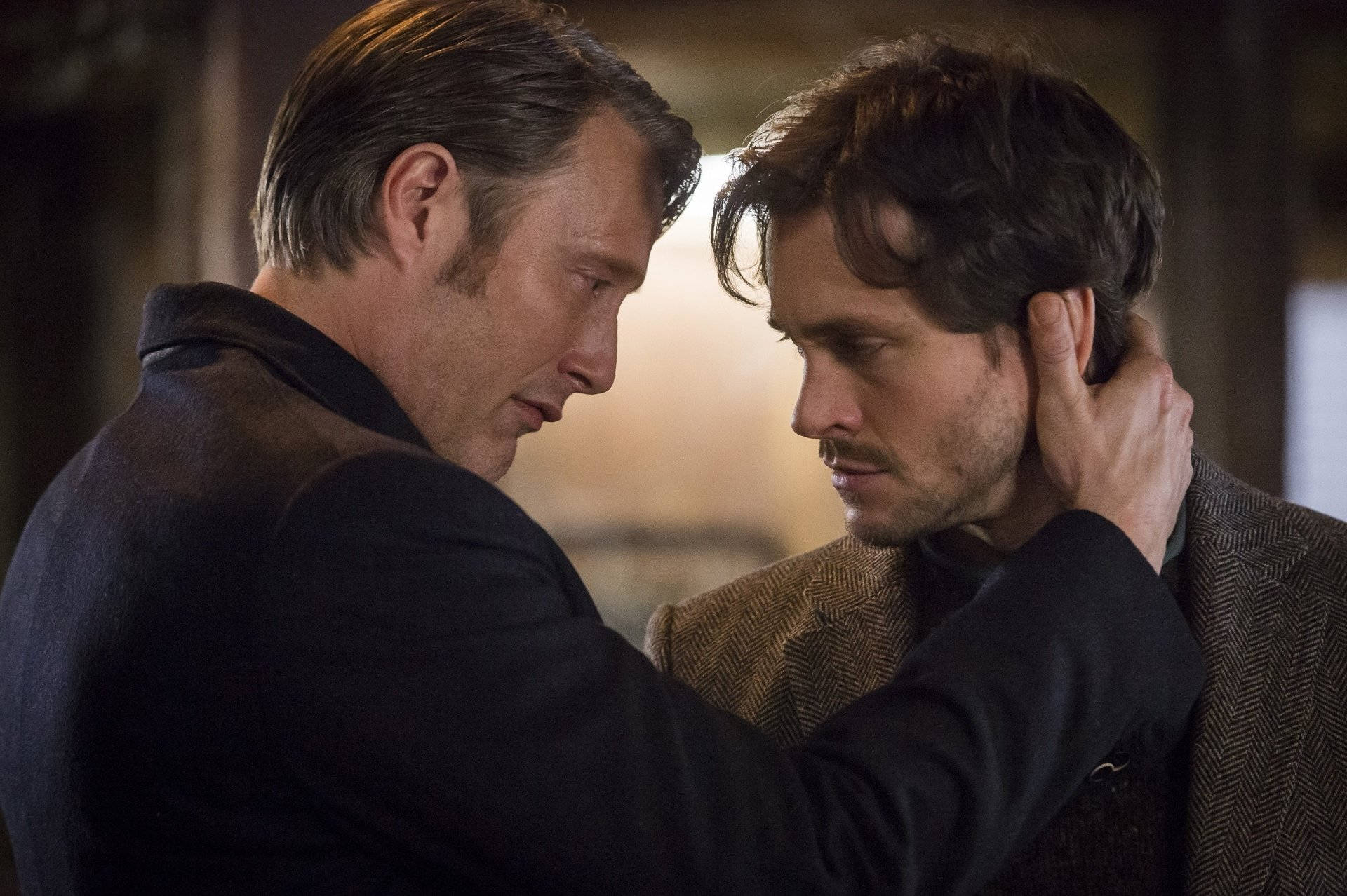 Hugh Dancy 桌布 壁紙 — 兩個男人在昏暗的房間裡緊張地近距離面對面，其中一個抓住另一個的脖子。