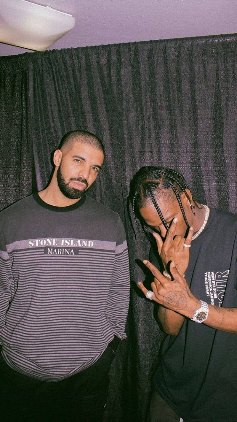 Drake 桌布 壁紙 — 兩個男人在深色窗簾前隨意擺姿勢，一個穿著條紋 Stone Island 襯衫，另一個梳著辮子並做手勢。