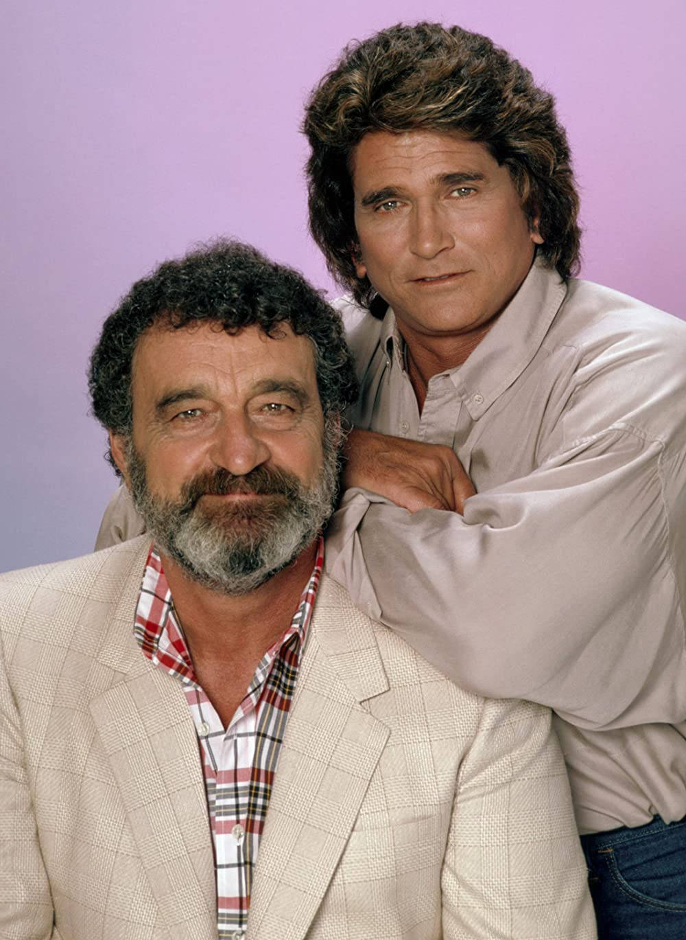 Michael Landon 桌布 壁紙 — 兩個男人在純色薰衣草背景前溫馨擺姿勢，一個留鬍鬚穿格紋襯衫和西裝外套，另一個頭髮蓬鬆傾身靠近。