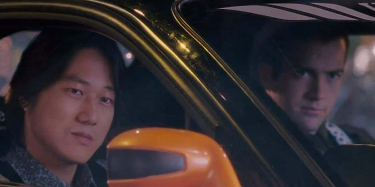 玩命關頭 桌布 壁紙 — 兩個男人夜晚坐在車裡，一個向前看，另一個透過車窗斜視側面