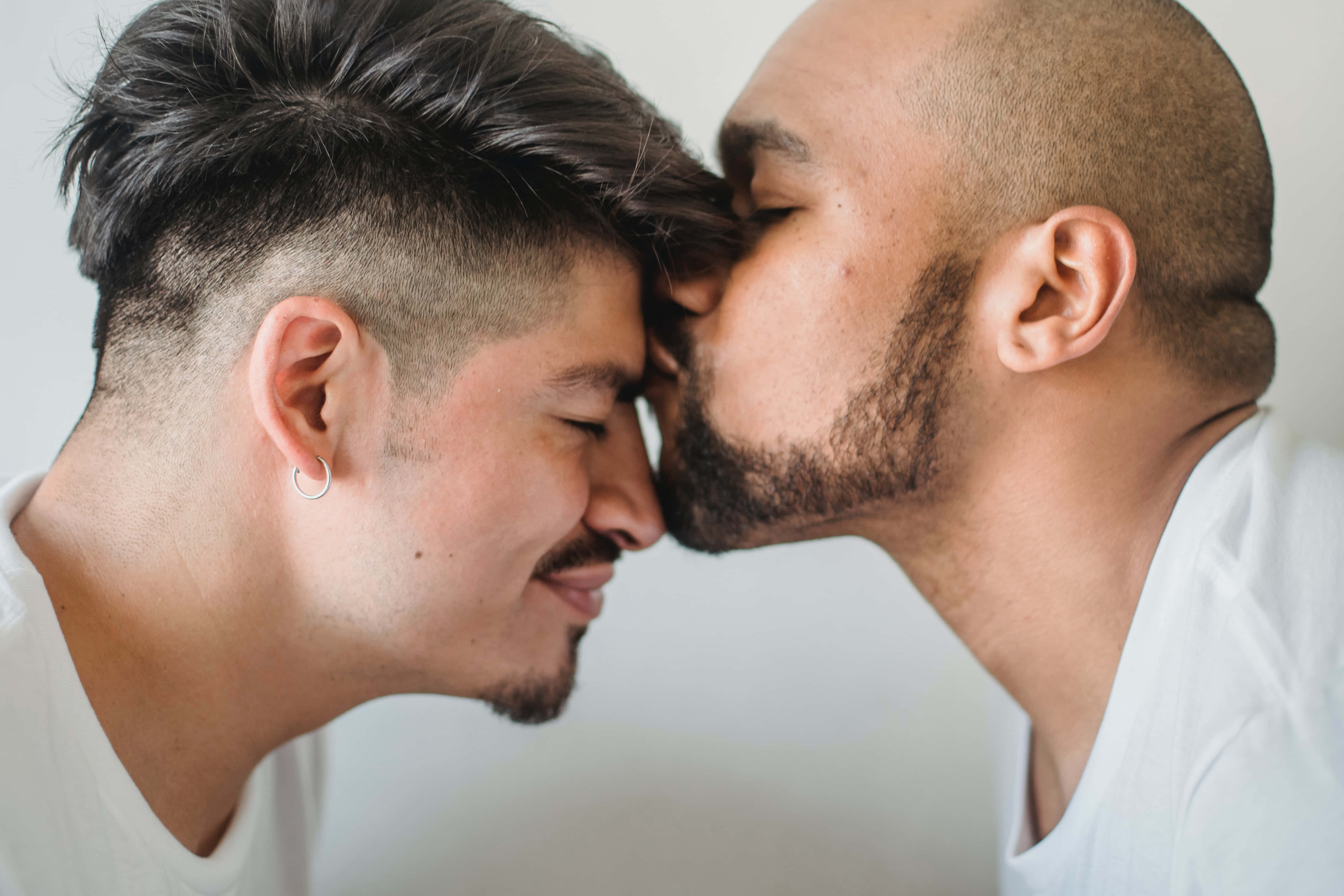 Forehead Kiss 桌布 壁紙 — 兩個男人額頭相觸，一人輕吻另一人的太陽穴，溫柔親密的瞬間。