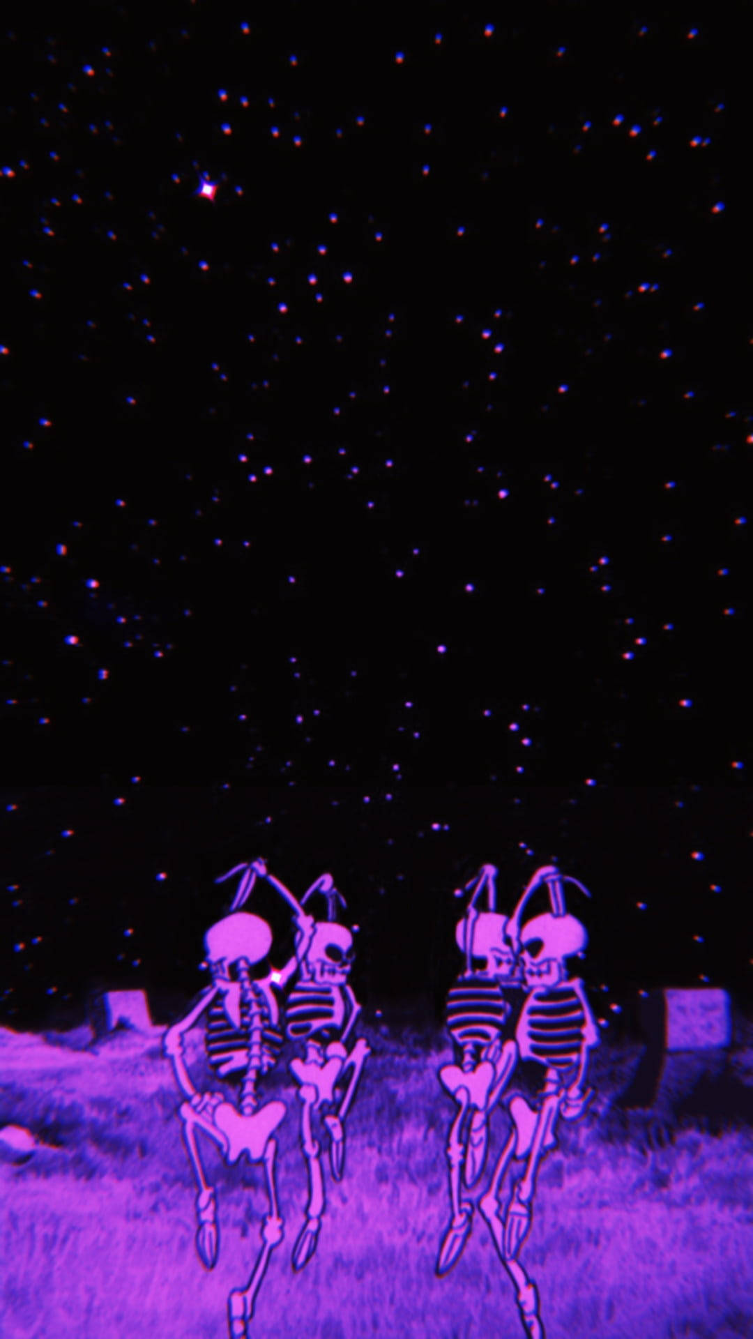 骷髏動圖 桌布 壁紙 — 兩個發光的紫色骷髏在星空下，在超現實的霓虹墓地場景中跳舞。