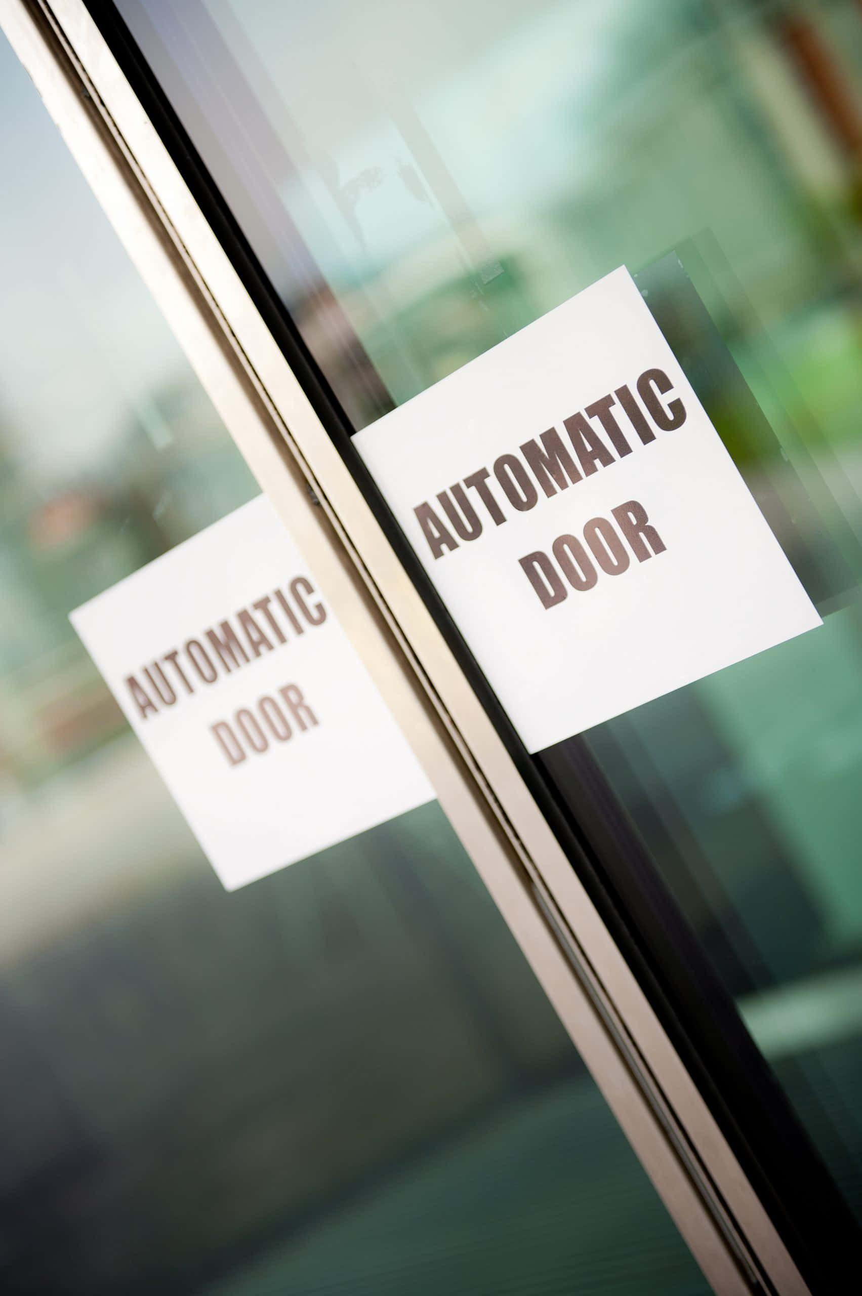 Automatic 桌布 壁紙 — 兩個白色標誌的特寫，上面寫著自動門，貼在帶有金屬框架的時尚玻璃門上。