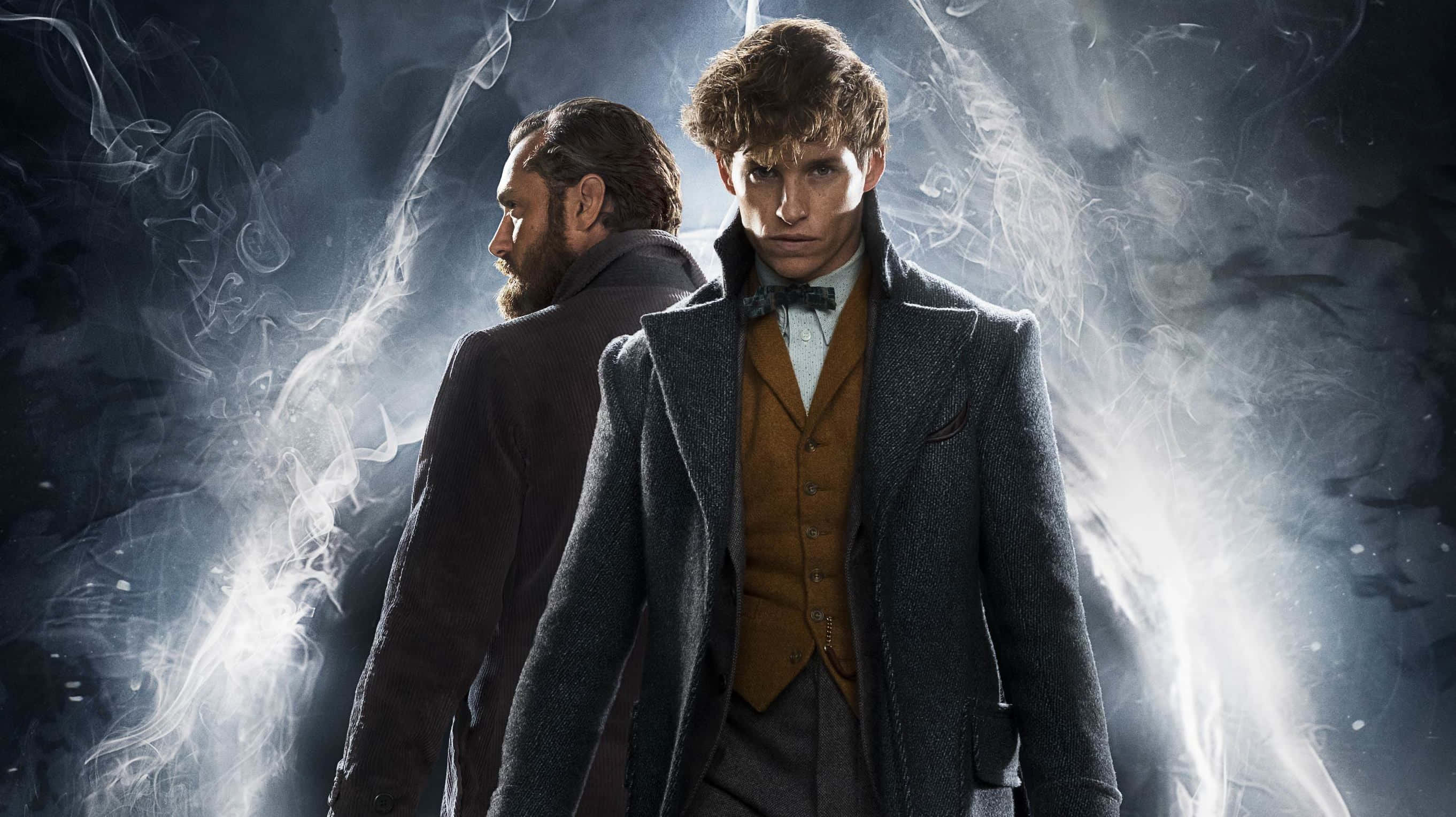 Fantastic Beasts 桌布 壁紙 — 兩個穿著復古外套的男人站在黑暗風暴背景前，被旋轉的煙霧和明亮的光線逆光照射。