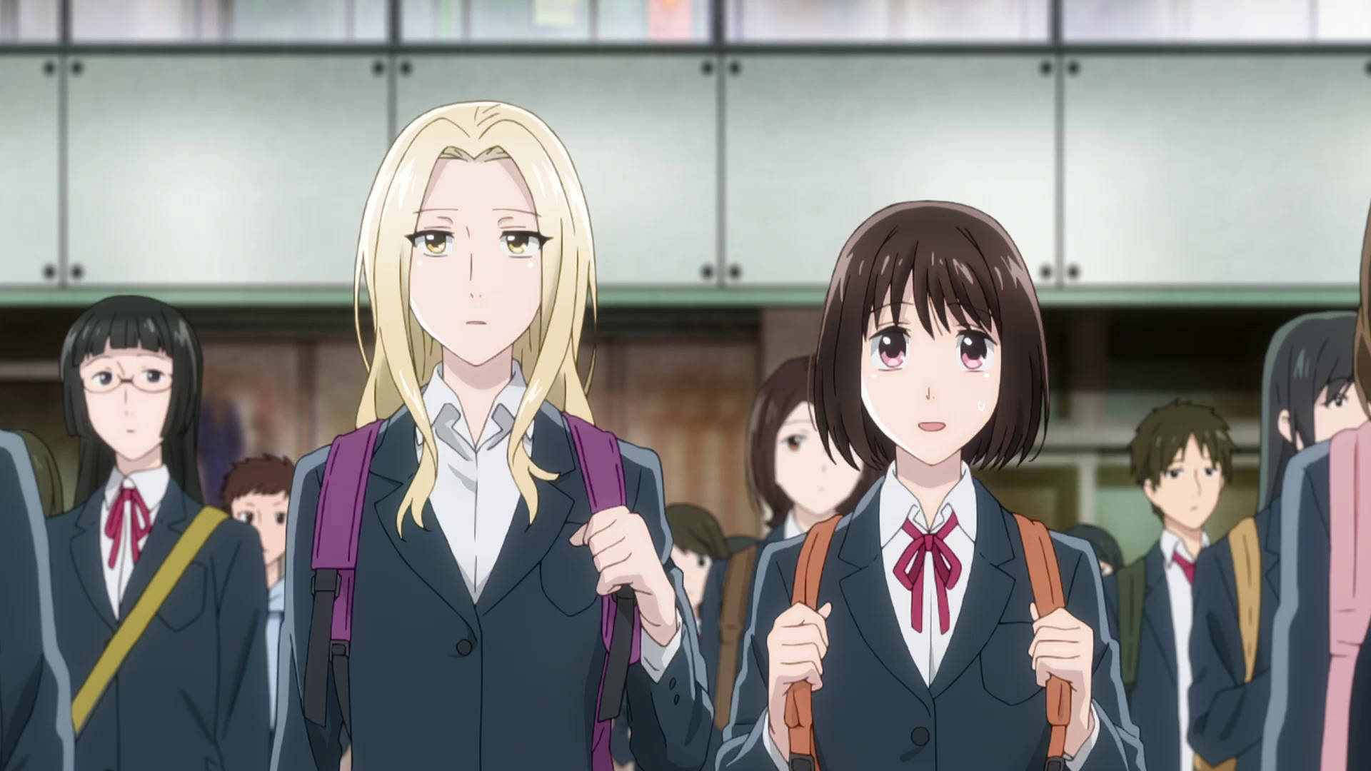 koikimo 桌布 壁紙 — 兩個穿著校服的動漫女孩在擁擠的走廊向前走，後面有其他學生。