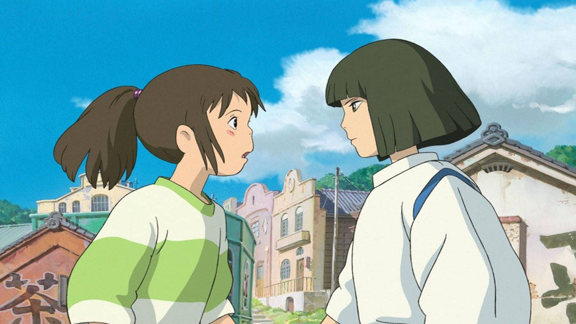 神隱少女 桌布 桌布 壁紙 — 兩個穿著校服的年輕女孩在色彩繽紛的傳統建築背景下，帶著好奇的表情面對面，頭頂是明亮的藍天。