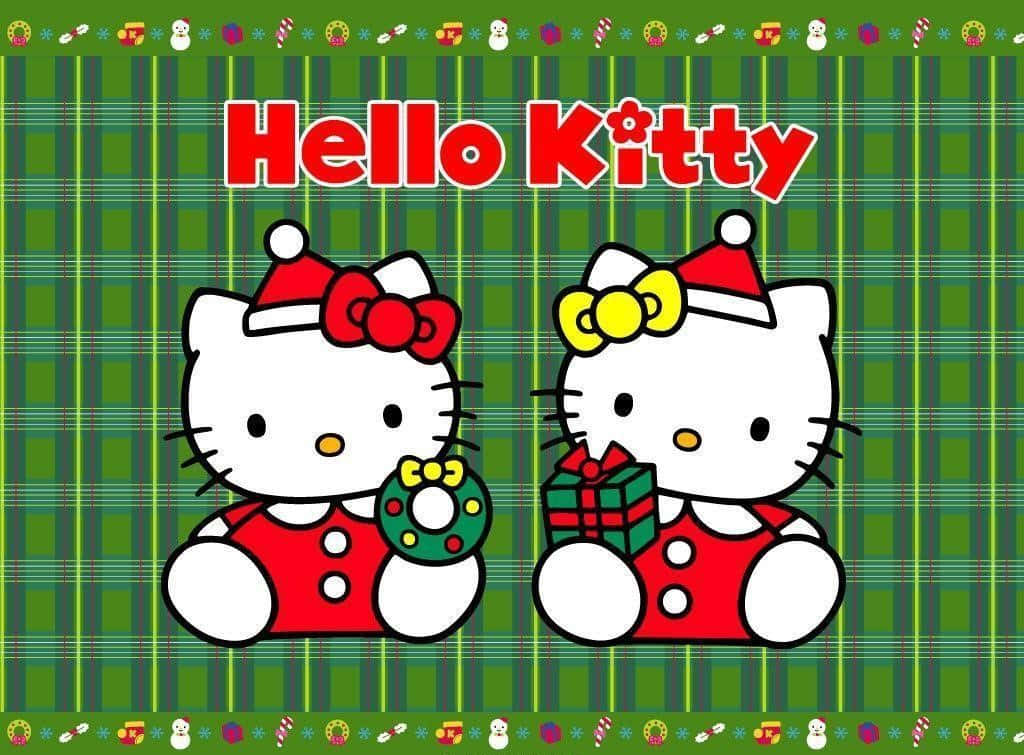 Hello Kitty Christmas 桌布 壁紙 — 兩個穿著紅色節日服裝的Hello Kitty角色，在綠色格子背景上拿著花環和禮物，帶有節日邊框。