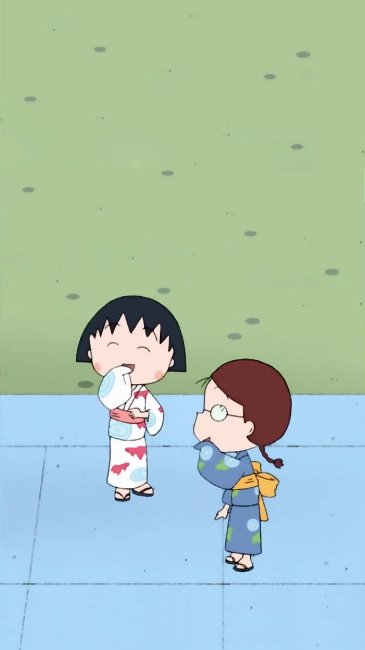 Chibi Maruko Chan 桌布 壁紙 — 兩個穿著色彩繽紛和服的動漫女孩在瓷磚地板上對著斑點綠牆啜飲杯子。