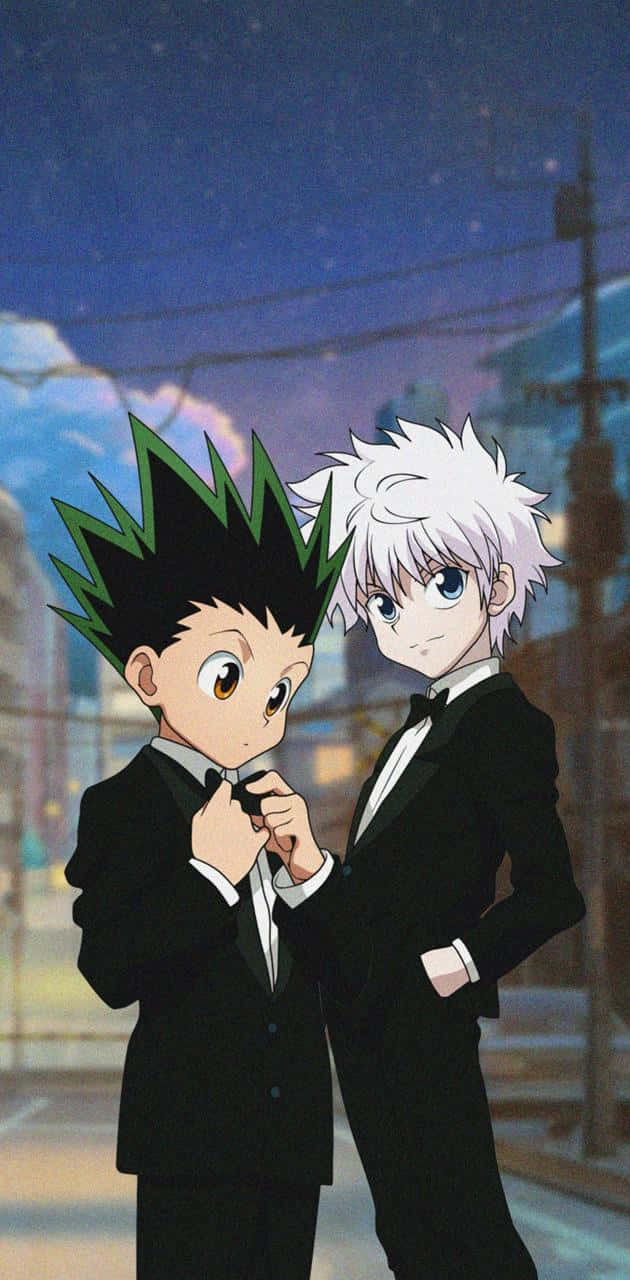 Gon And Killua 桌布 壁紙 — 兩個穿著黑色燕尾服的動畫男孩在繁星點點的夜空下，背後城市燈光柔和閃爍，彼此靠近站立。