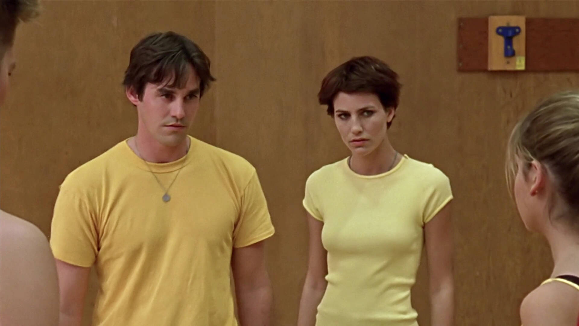 Nicholas Brendon 桌布 壁紙 — 兩個穿黃色襯衫的人站在木房間裡，表情緊張地面對其他人。
