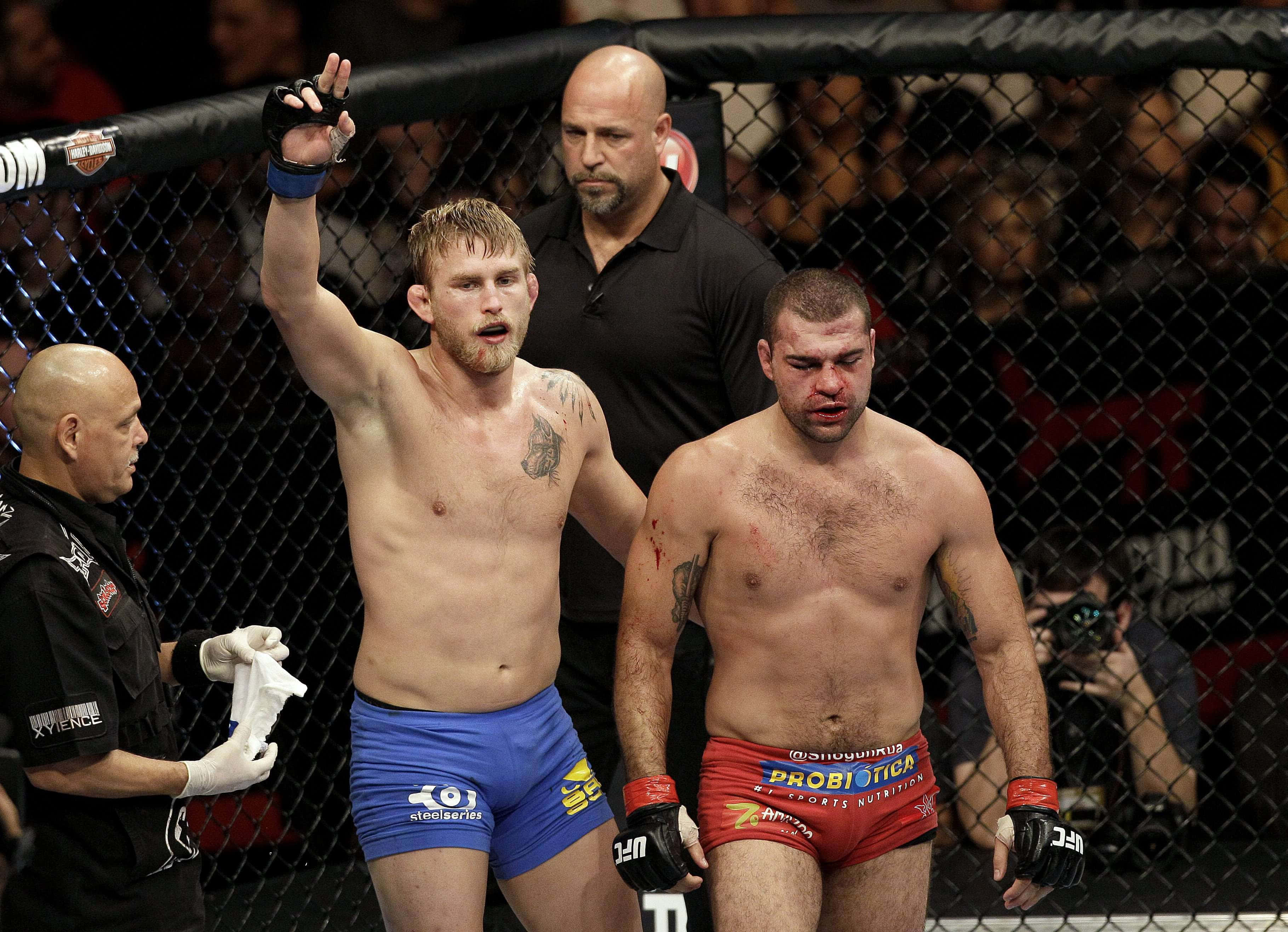 Champion 桌布 壁紙 — 兩個筋疲力盡的MMA拳手在籠中，一個舉手勝利，另一個低頭失敗。