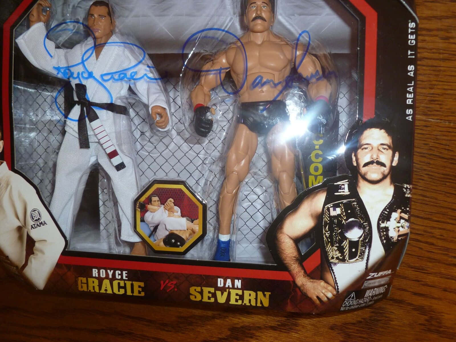toys 桌布 壁紙 — 兩個簽名的Royce Gracie和Dan Severn動作人偶在木製表面上的摔角玩具包裝中。