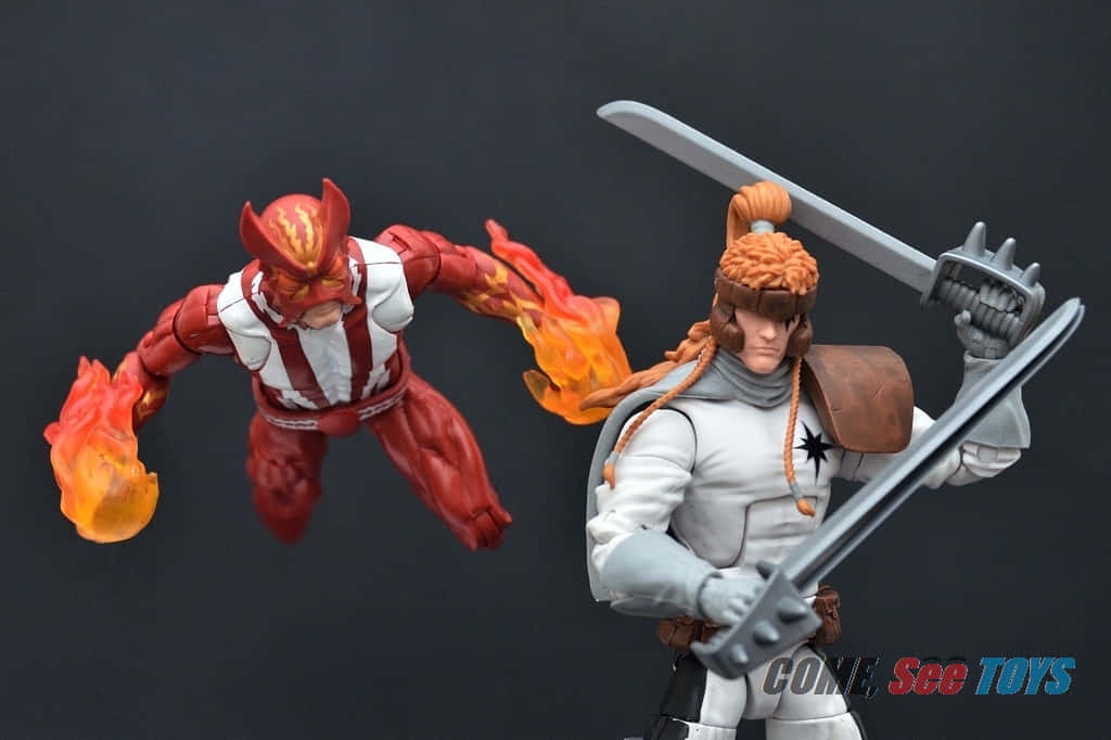 Shatterstar 桌布 壁紙 — 兩個精細的動作人偶，一個是火紅色帶火焰，另一個是白色盔甲持劍，在深色背景前動態擺姿勢。