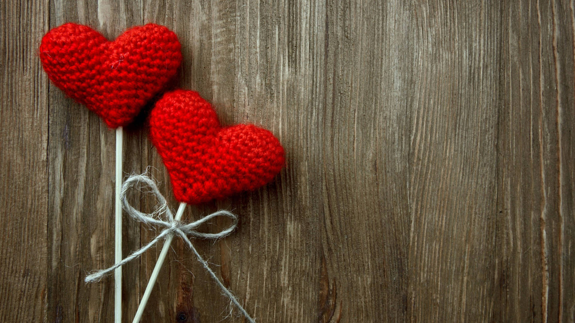 Happy Valentines Day 桌布 壁紙 — 兩個紅色鉤織心形用麻繩綁在一起，放在經風化的木質表面上。