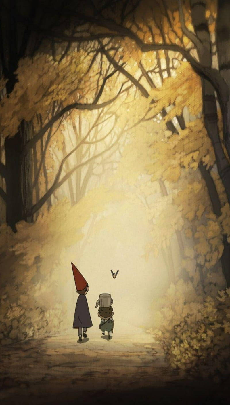 over the garden wall 桌布 壁紙 — 兩個細小身影手牽手，走在陽光灑落的秋日森林小徑上，四周環繞著金黃的樹葉和光禿的樹枝。