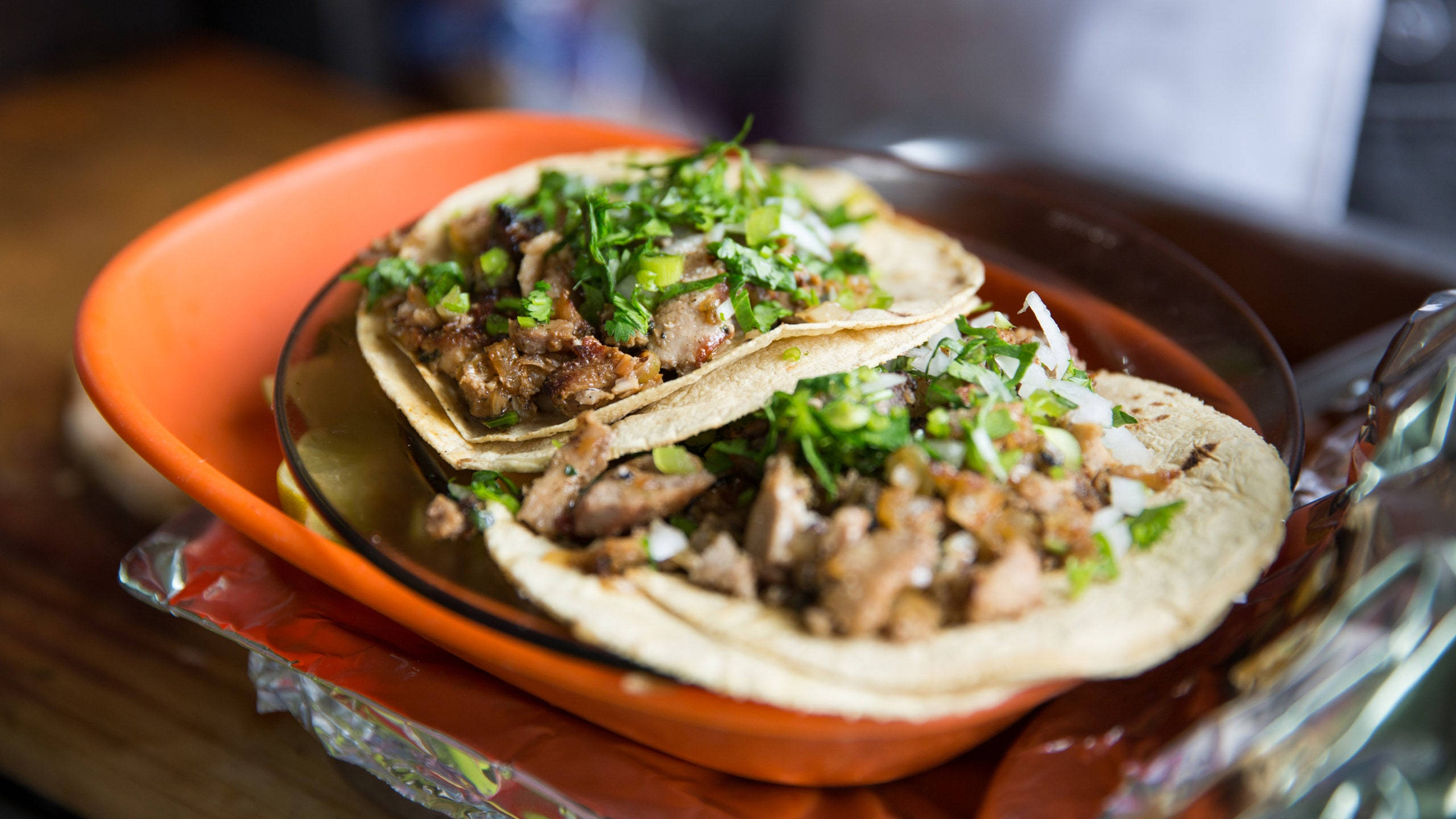 Mexican Food 桌布 壁紙 — 兩個美味的墨西哥捲餅，內有撕碎的肉和新鮮的香菜，放在一個鮮豔的橙色碗裡，置於木桌上。