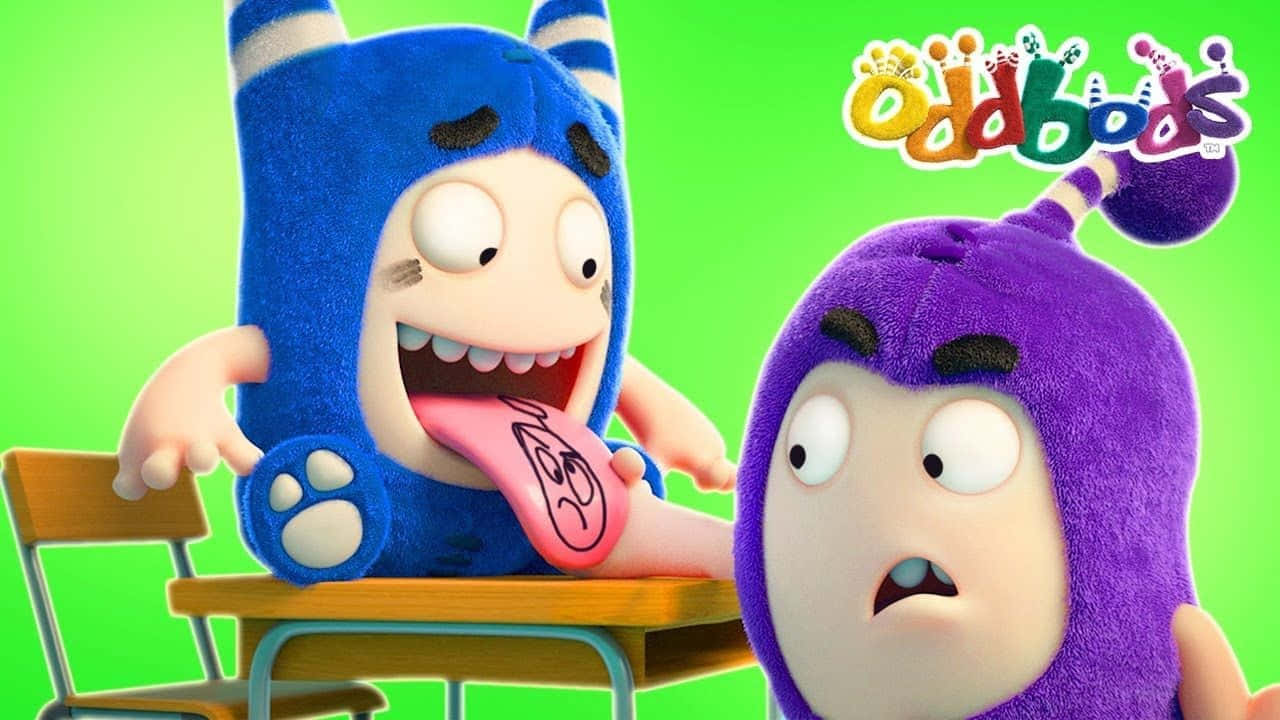 Cartoon 桌布 壁紙 — 兩個色彩繽紛的Oddbods角色，一個藍色伸舌頭，一個紫色震驚地看著書桌。