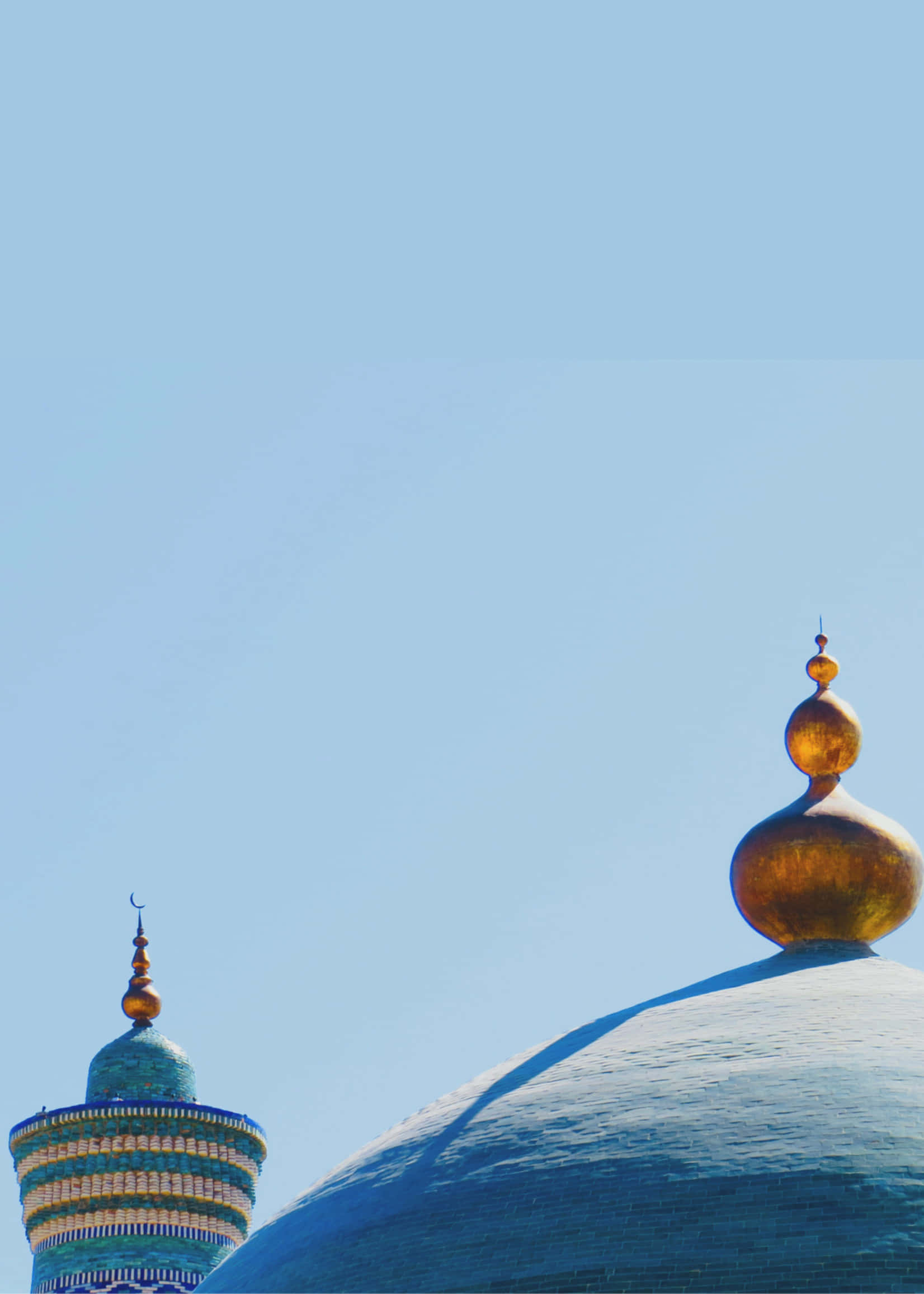 Islamic Ornament 桌布 壁紙 — 兩個裝飾華麗的圓頂，頂部有金色尖頂，在晴朗的藍天下，沐浴在明亮的陽光中。