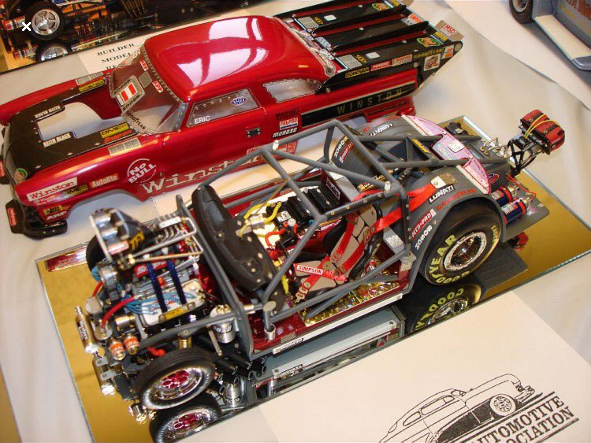 Car Model 桌布 壁紙 — 兩個詳細的賽車模型，一個紅色經典直線加速賽車和一個暴露的灰色開輪賽車，展示在反光表面上。