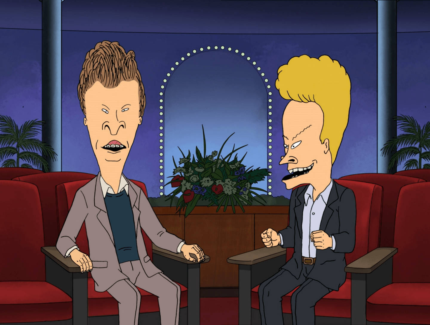 Beavis 桌布 壁紙 — 兩個誇張特徵的動畫角色坐在紅色椅子上，在昏暗的錄影棚環境中面對面。