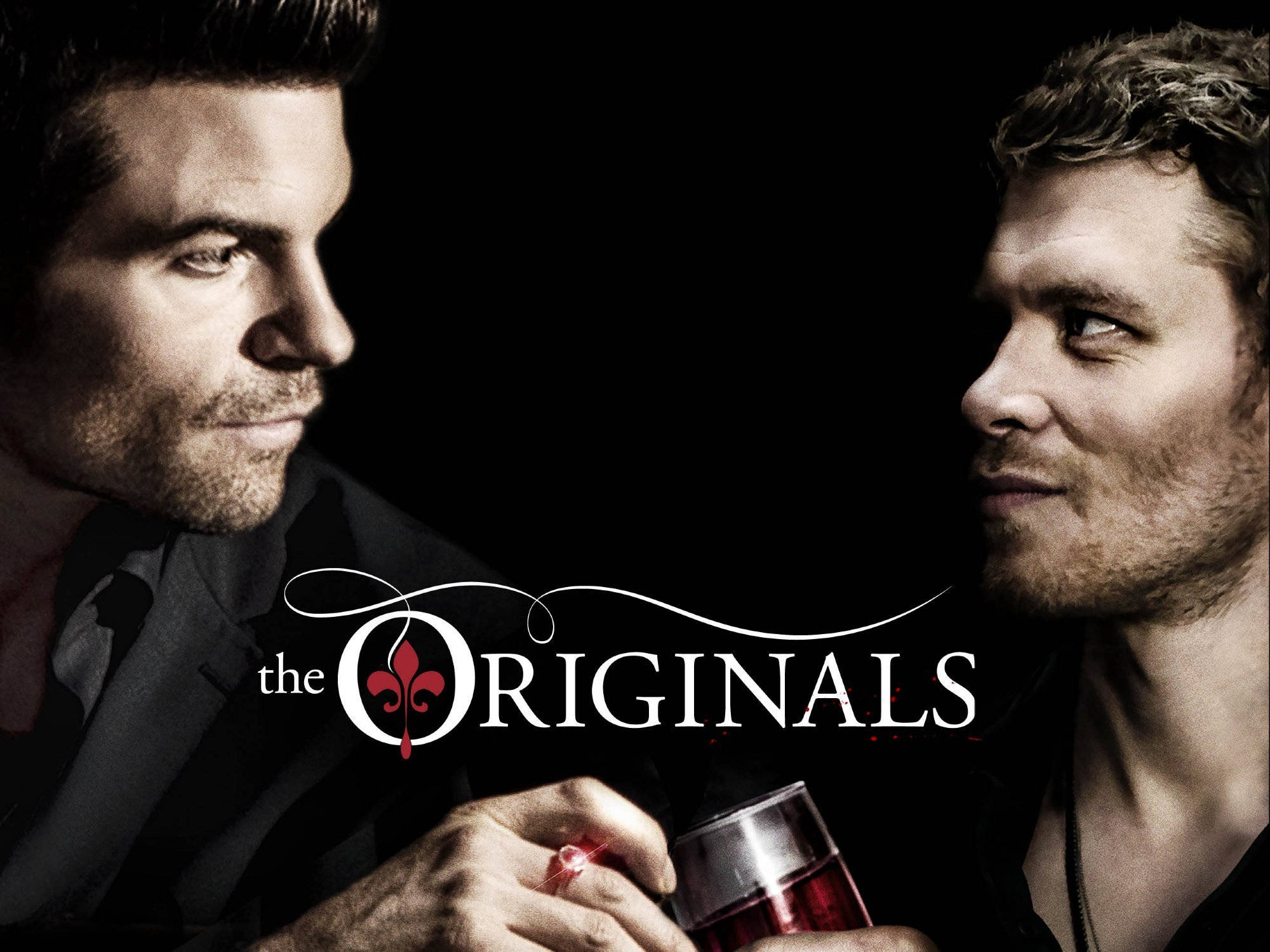 Originals 桌布 壁紙 — 兩個身穿深色西裝的男子在黑色背景前激烈對峙，手持一杯帶有標題標誌的紅色液體。