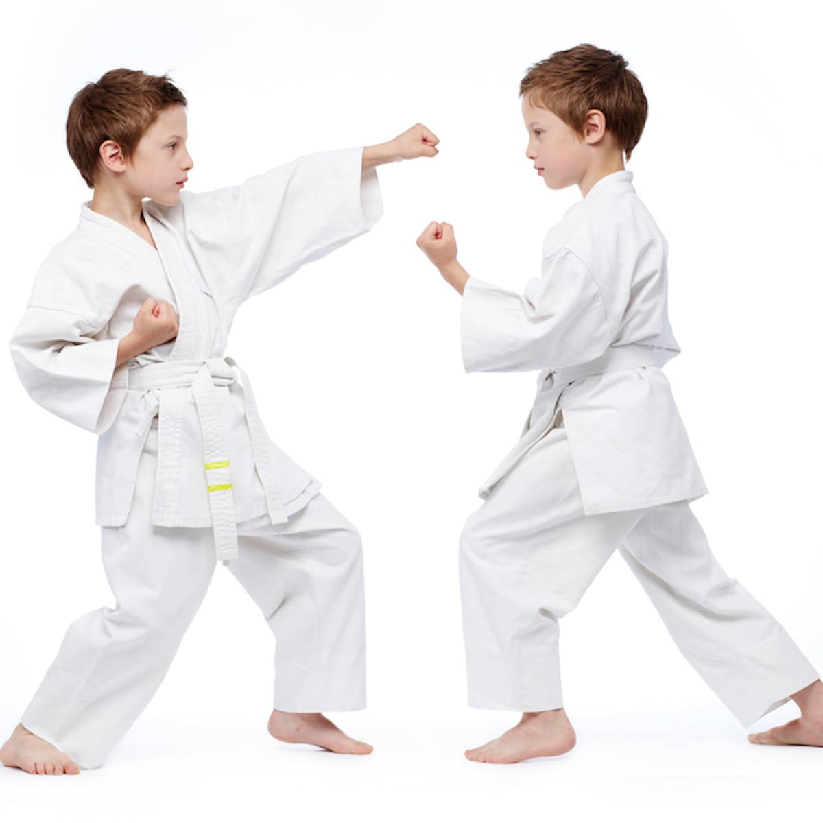 Karate 桌布 壁紙 — 兩個身穿白色空手道道服的男孩，在純白背景前以專注的對打姿勢對峙。