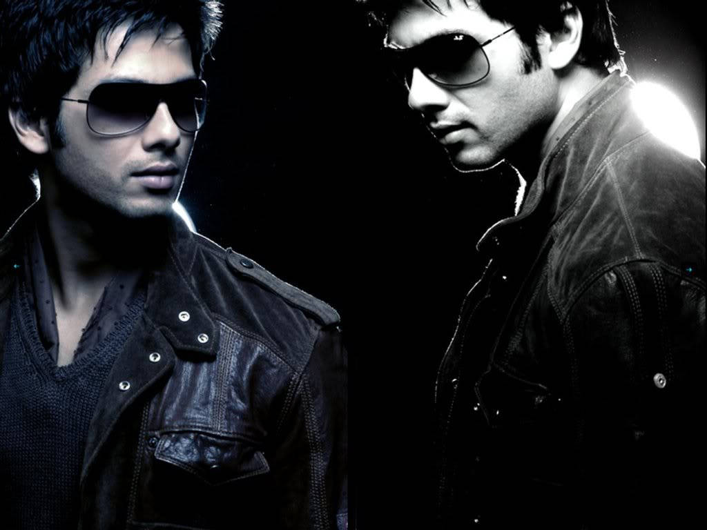 Shahid Kapoor 桌布 壁紙 — 兩個身穿皮夾克和太陽眼鏡的男人在黑暗背景中，以明亮的背光戲劇性地擺姿勢。