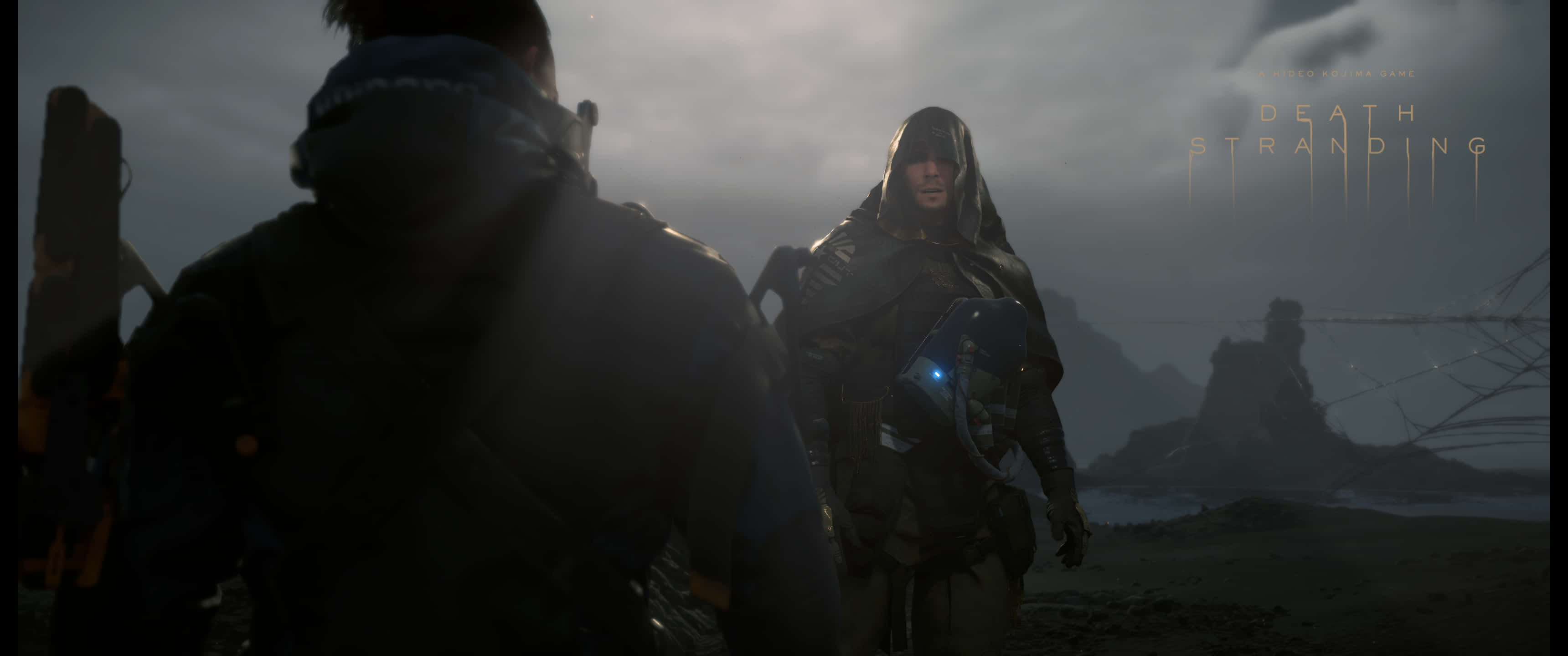 3440x1440p Death Stranding 桌布 壁紙 — 兩個身穿黑色裝備的人物站在迷霧籠罩、荒涼的風景中，陰沉天空下，遠山和一個發光的藍色裝置。