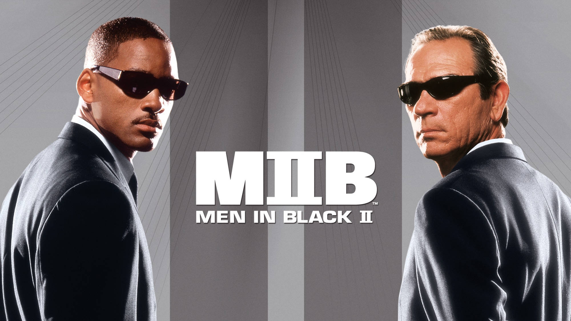 Men In Black 桌布 壁紙 — 兩個身穿黑色西裝和太陽眼鏡的男人在灰色條紋背景上面對面，帶有「Men in Black II」文字。