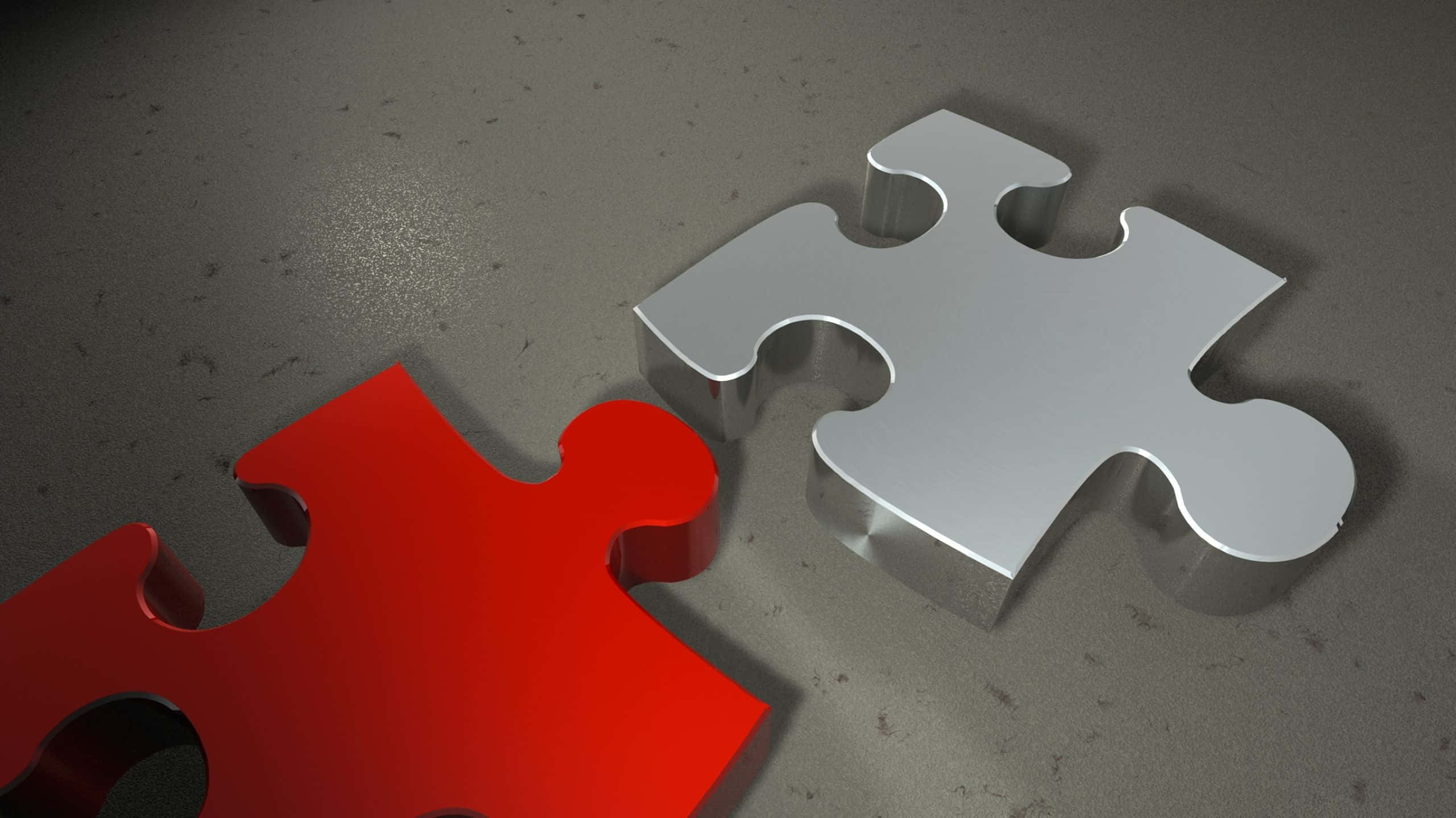 Puzzle 桌布 壁紙 — 兩個金屬拼圖塊，一個紅色一個銀色，放在灰色紋理表面上，投下柔和陰影。