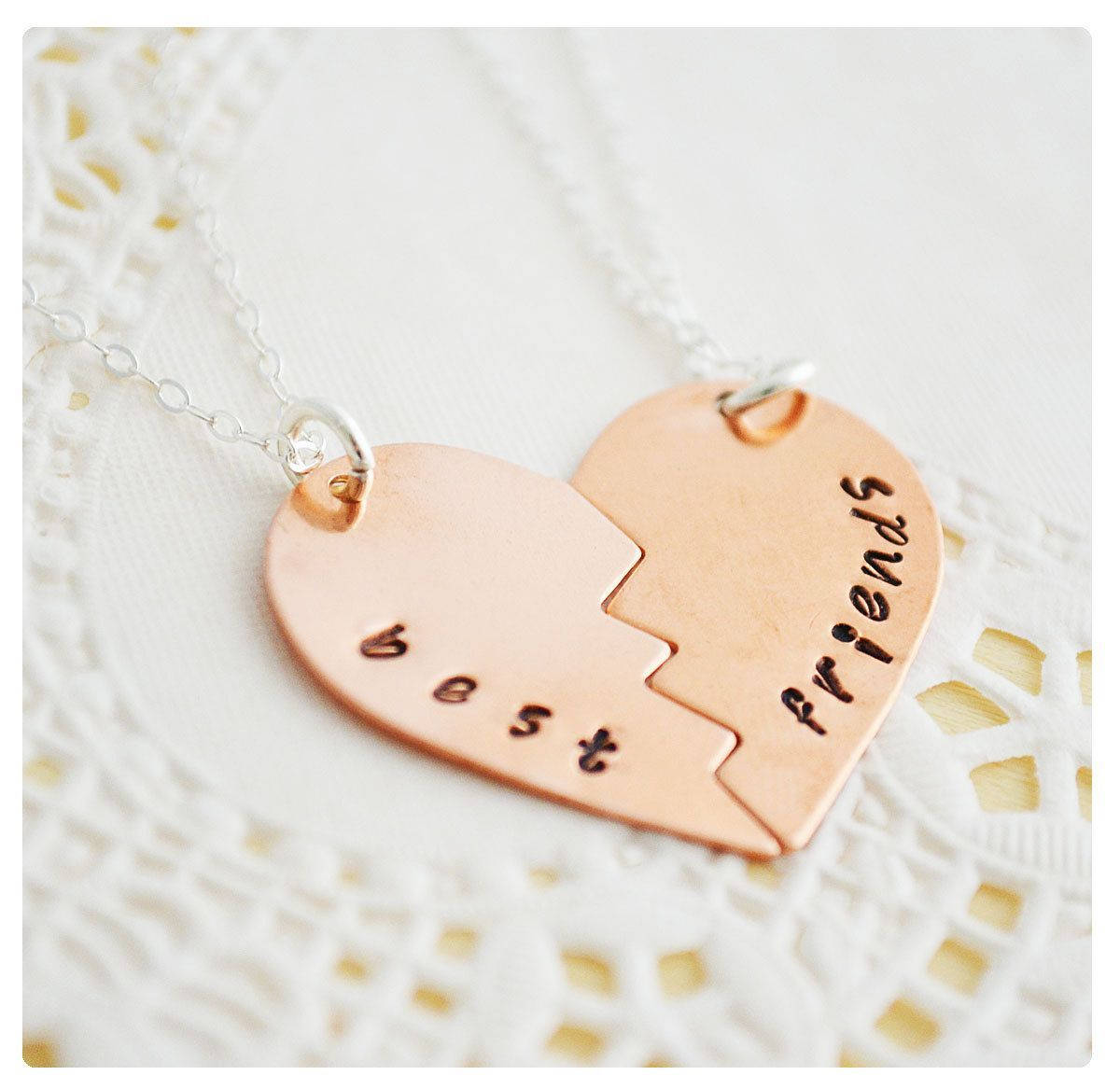 Cute Best Friend 桌布 壁紙 — 兩個銅製心形吊墜半邊，刻有「閨蜜」字樣，放在白色蕾絲背景上。