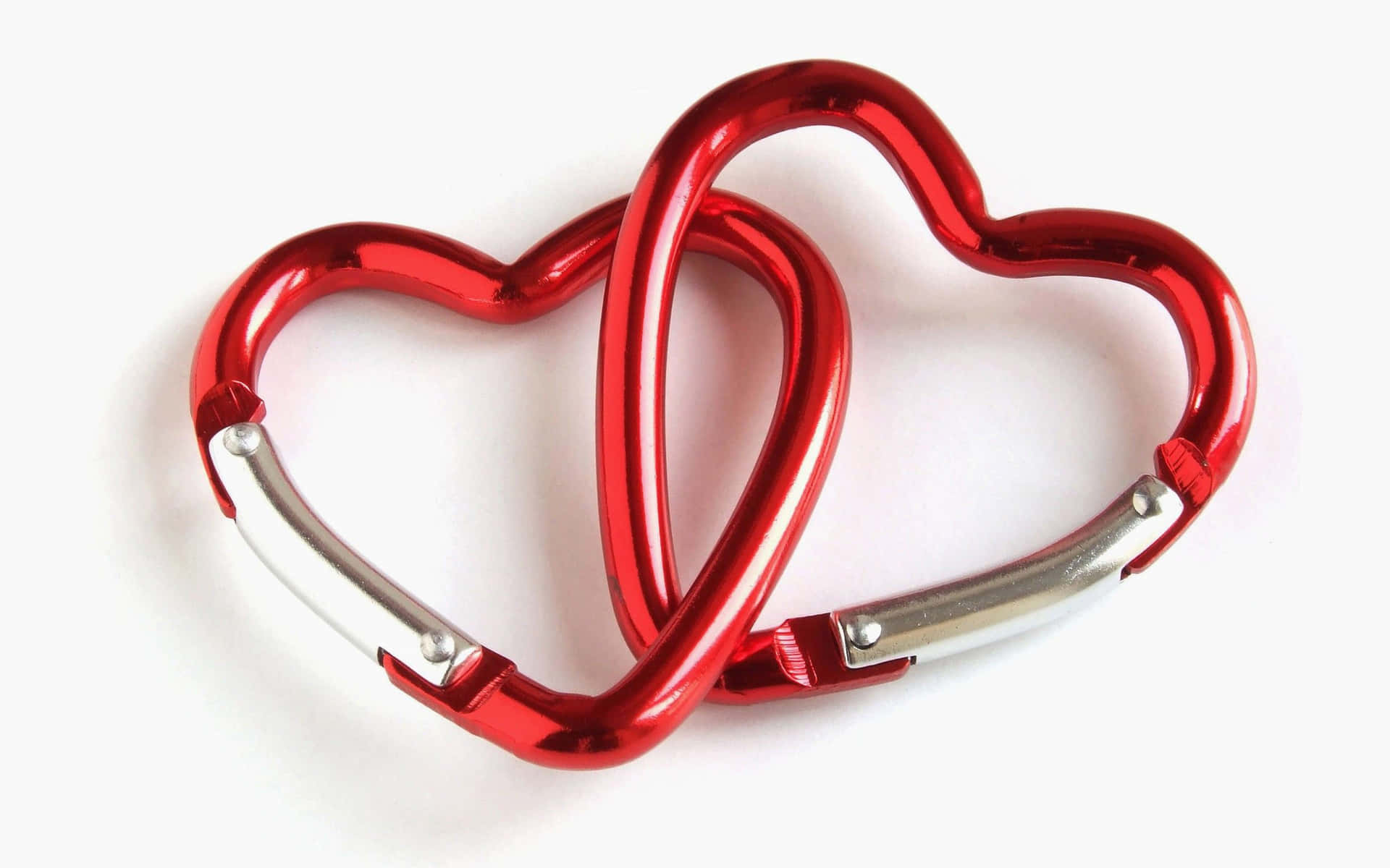 Heart 桌布 壁紙 — 兩個閃亮的紅色心形登山扣在潔白背景上互相扣連。